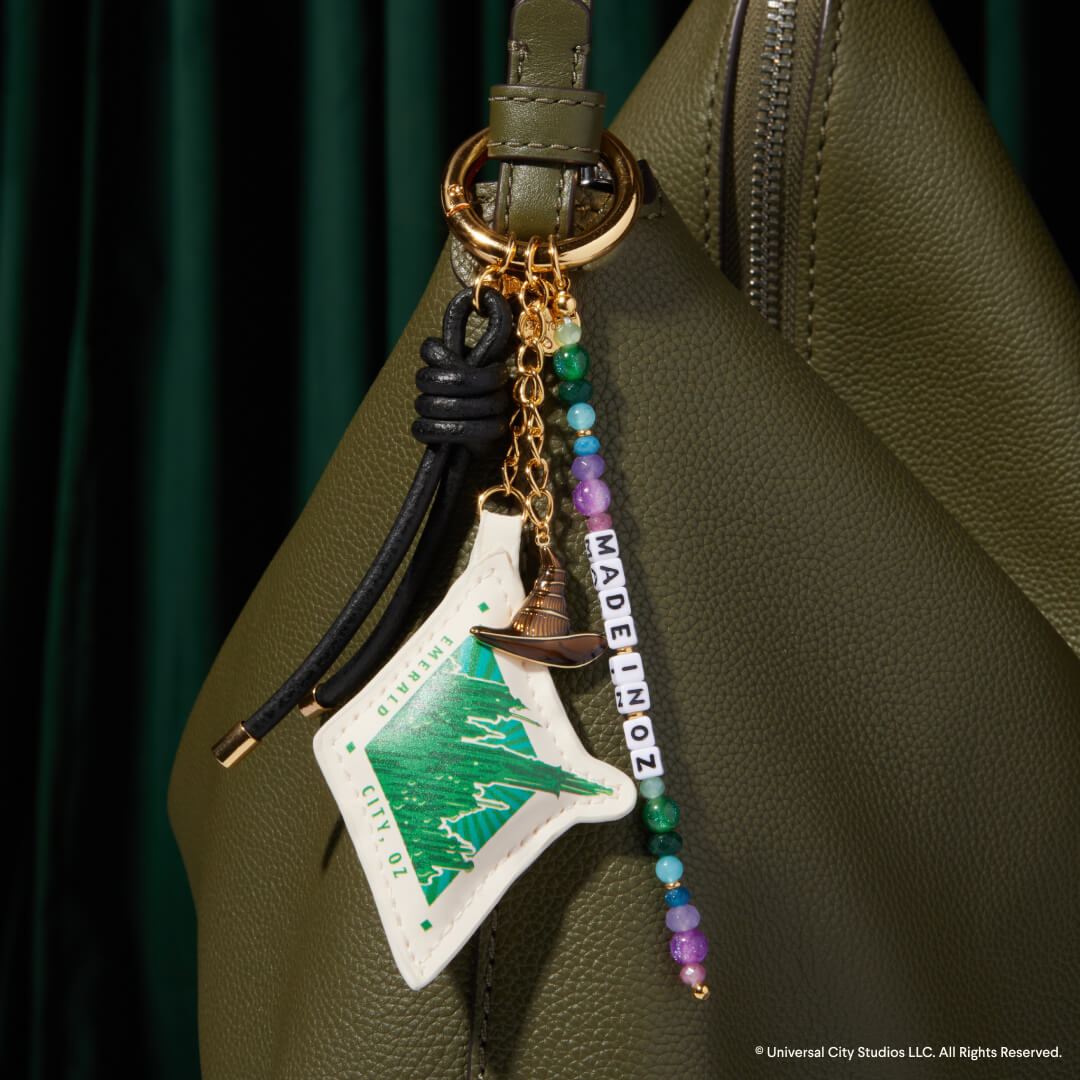 Keychain with decorative elements attached to a green bag
