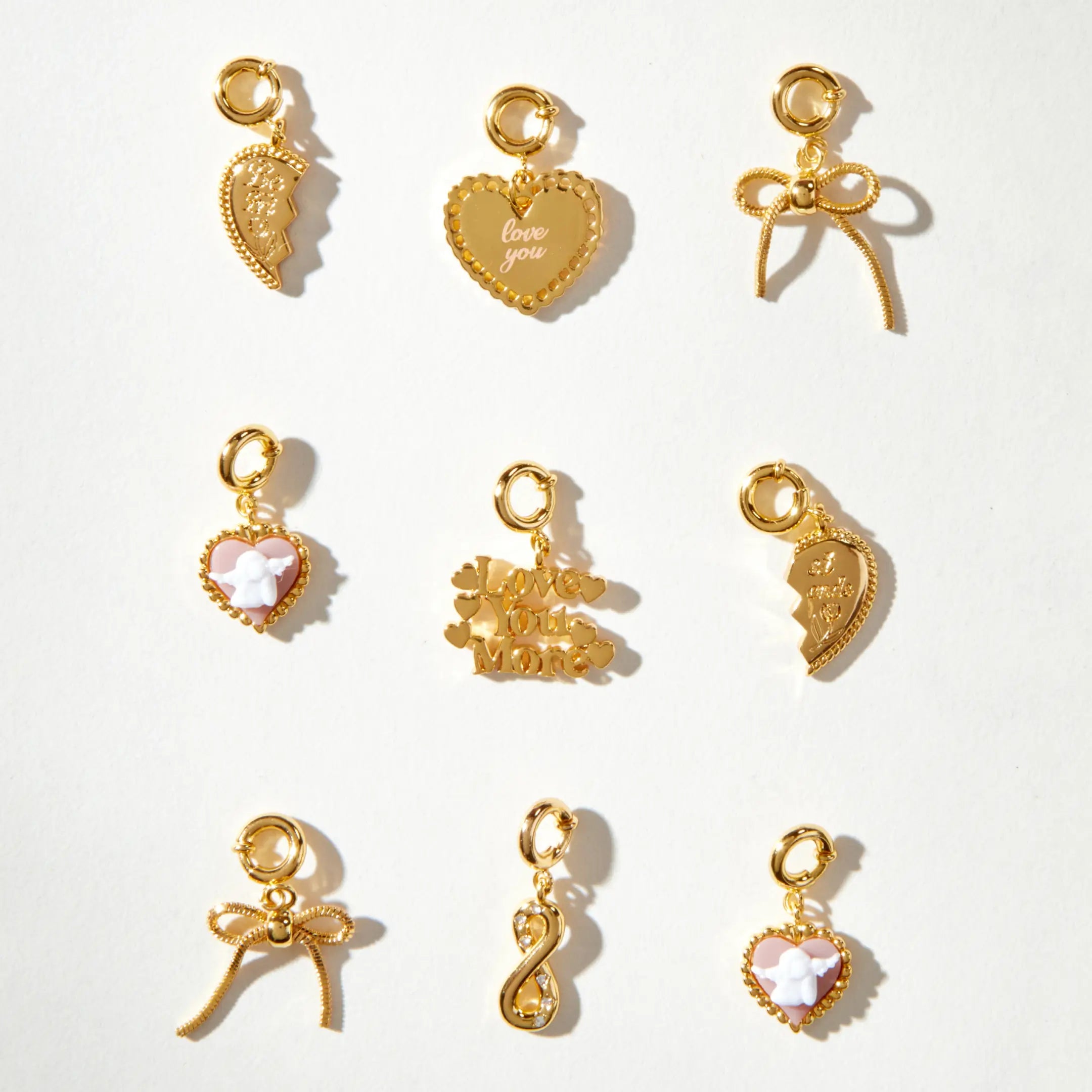 Gold charms with various designs on a white background