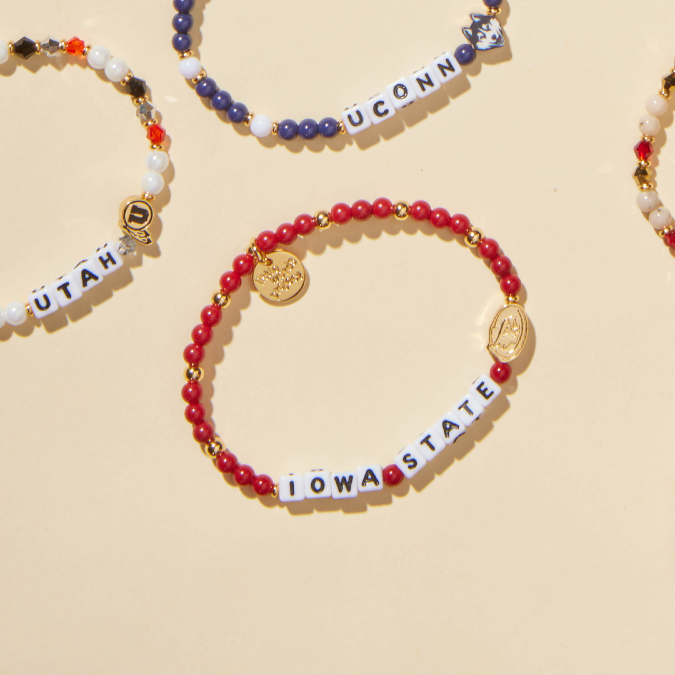 Bracelets with letter beads spelling out names on a beige background