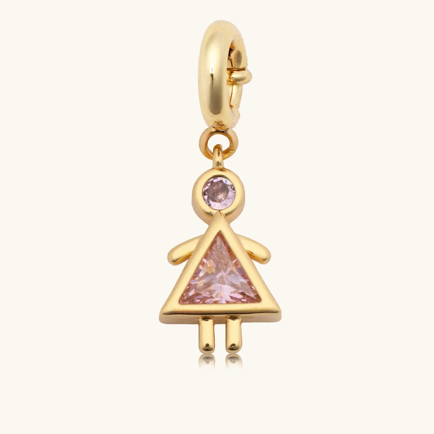 A gold dangle charm in the shape of a girl figure, featuring a round pink gemstone as the head and a triangular pink gemstone as the body forming a dress silhouette, with gold arms and legs, attached to a gold spring-ring clasp.