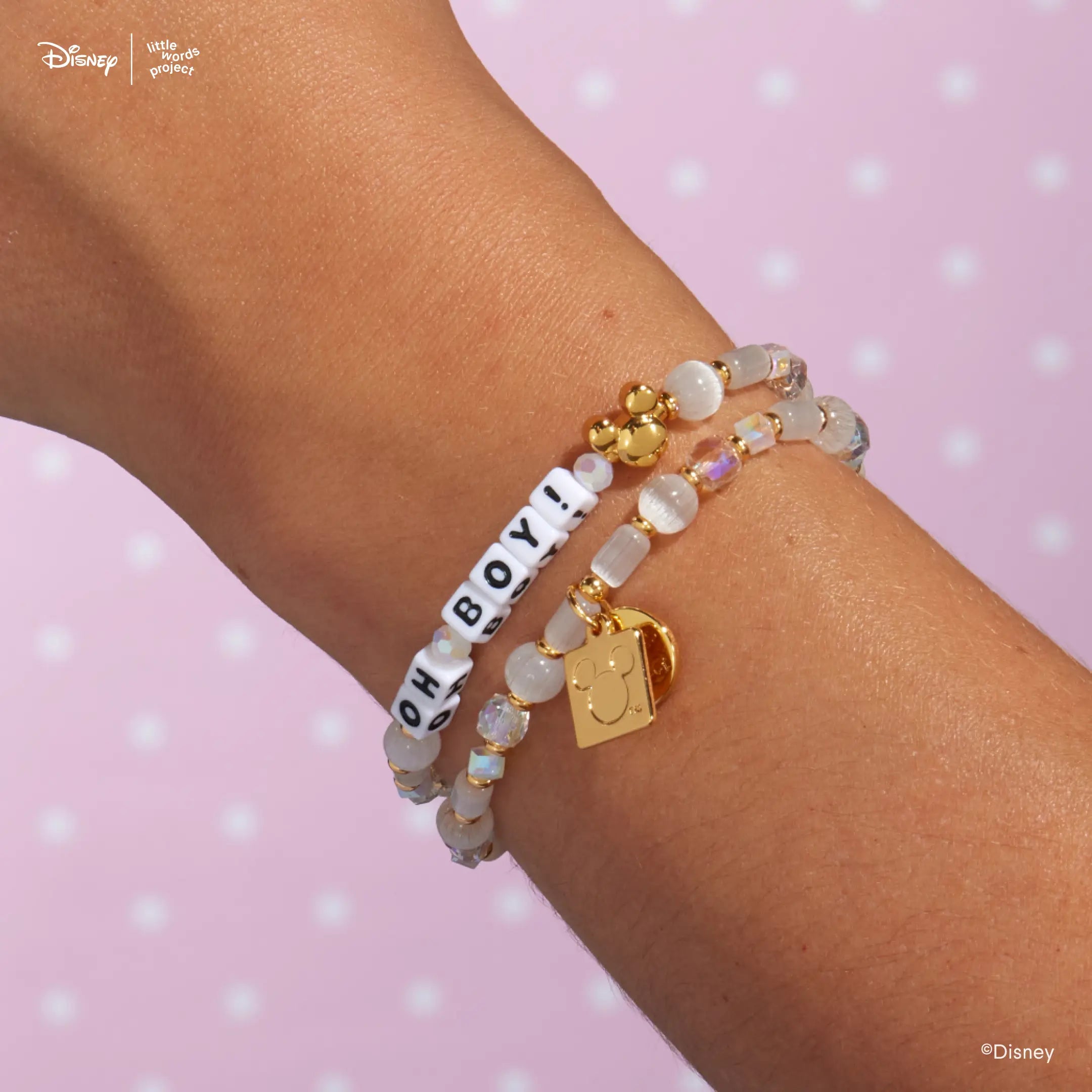 Oh Boy! Disney Mickey and Friends bracelet worn on a wrist against a pink backdrop, layered with a second pastel beaded bracelet