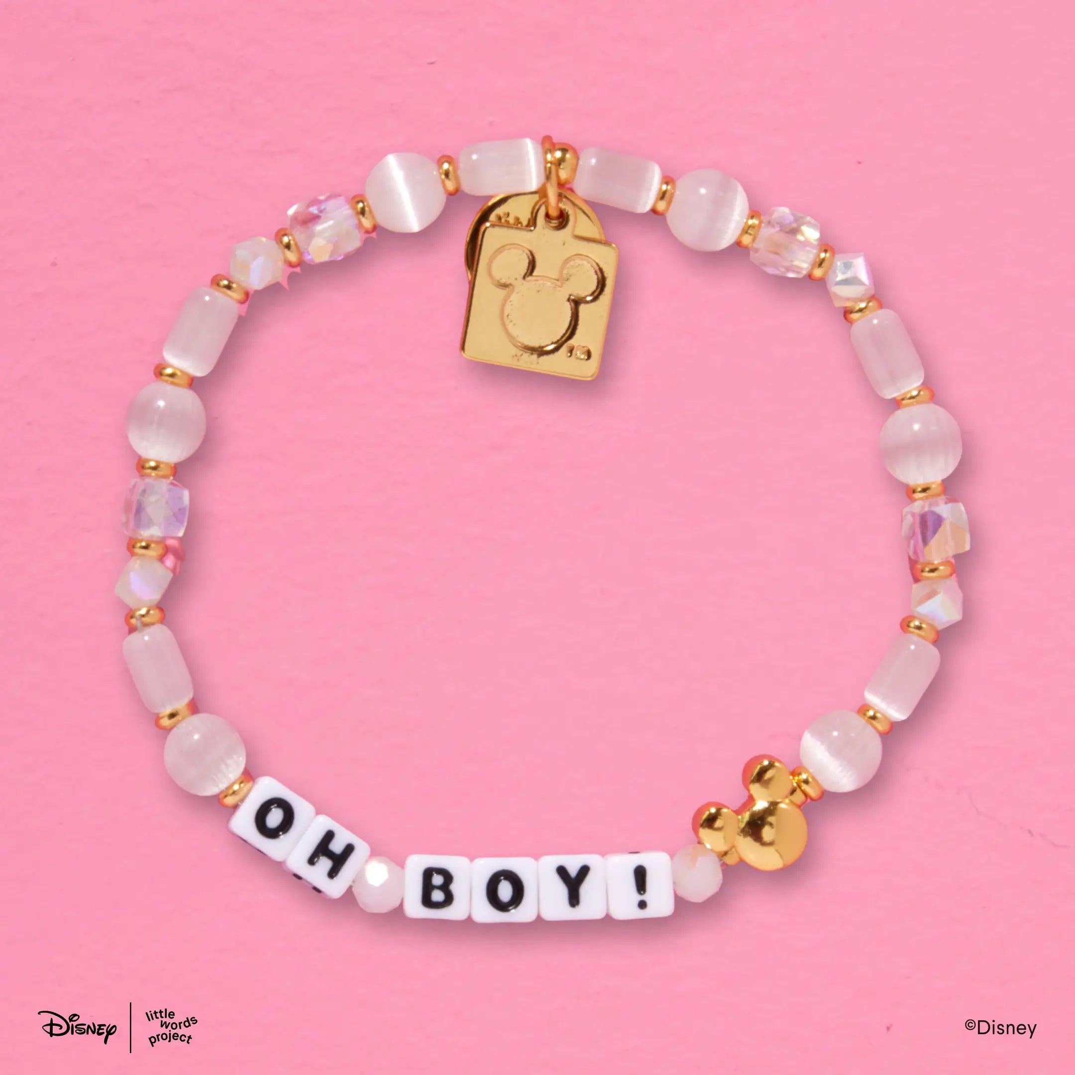 Oh Boy! Disney Mickey and Friends bracelet flat lay on pink with pink and lavender beads, a gold Mickey Mouse bead and a gold plated casted Mickey Mouse tag charm