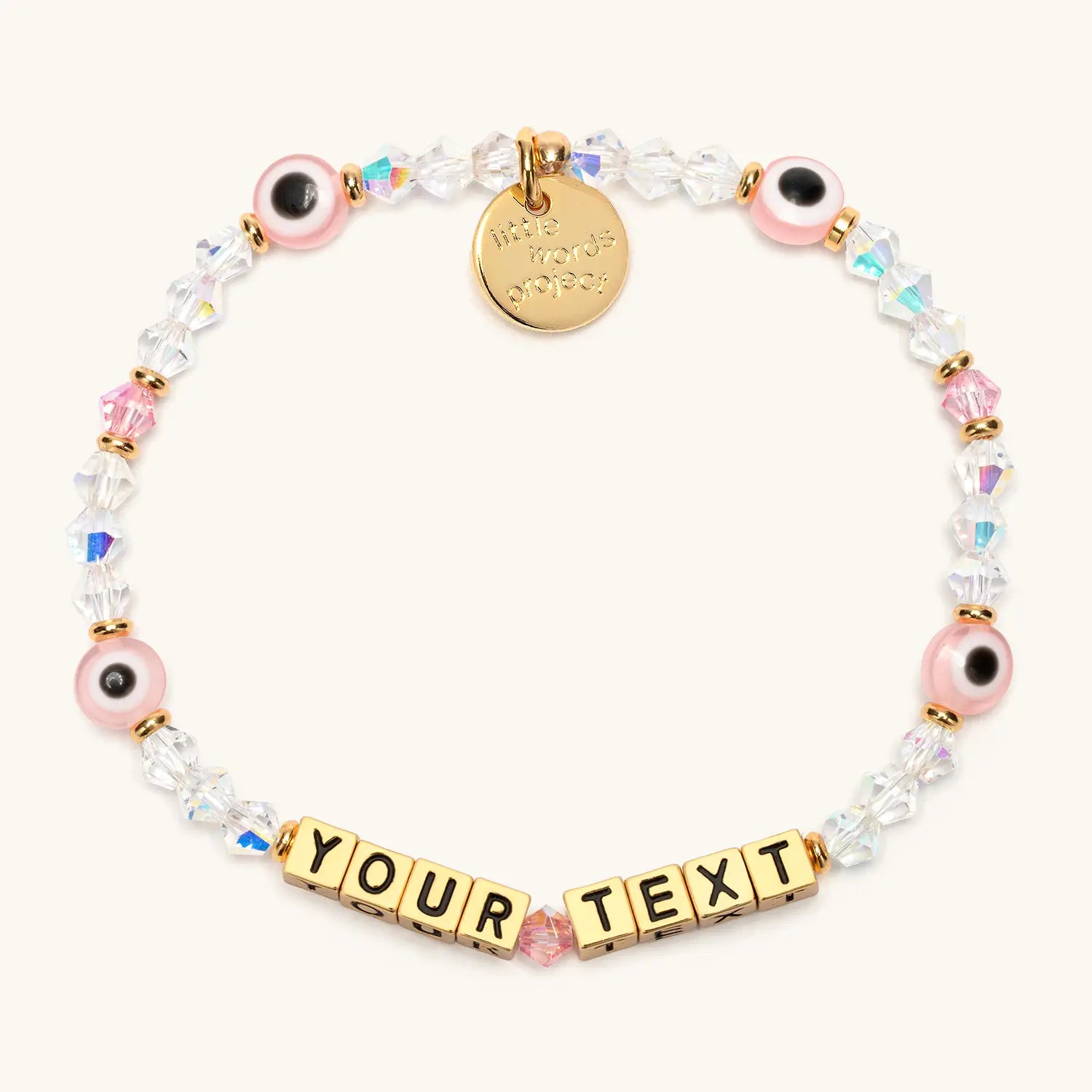 Custom Pink Evil Eye bracelet with gold letter beads reading YOUR TEXT, pink evil eye beads, clear crystals, and a gold Little Words Project charm