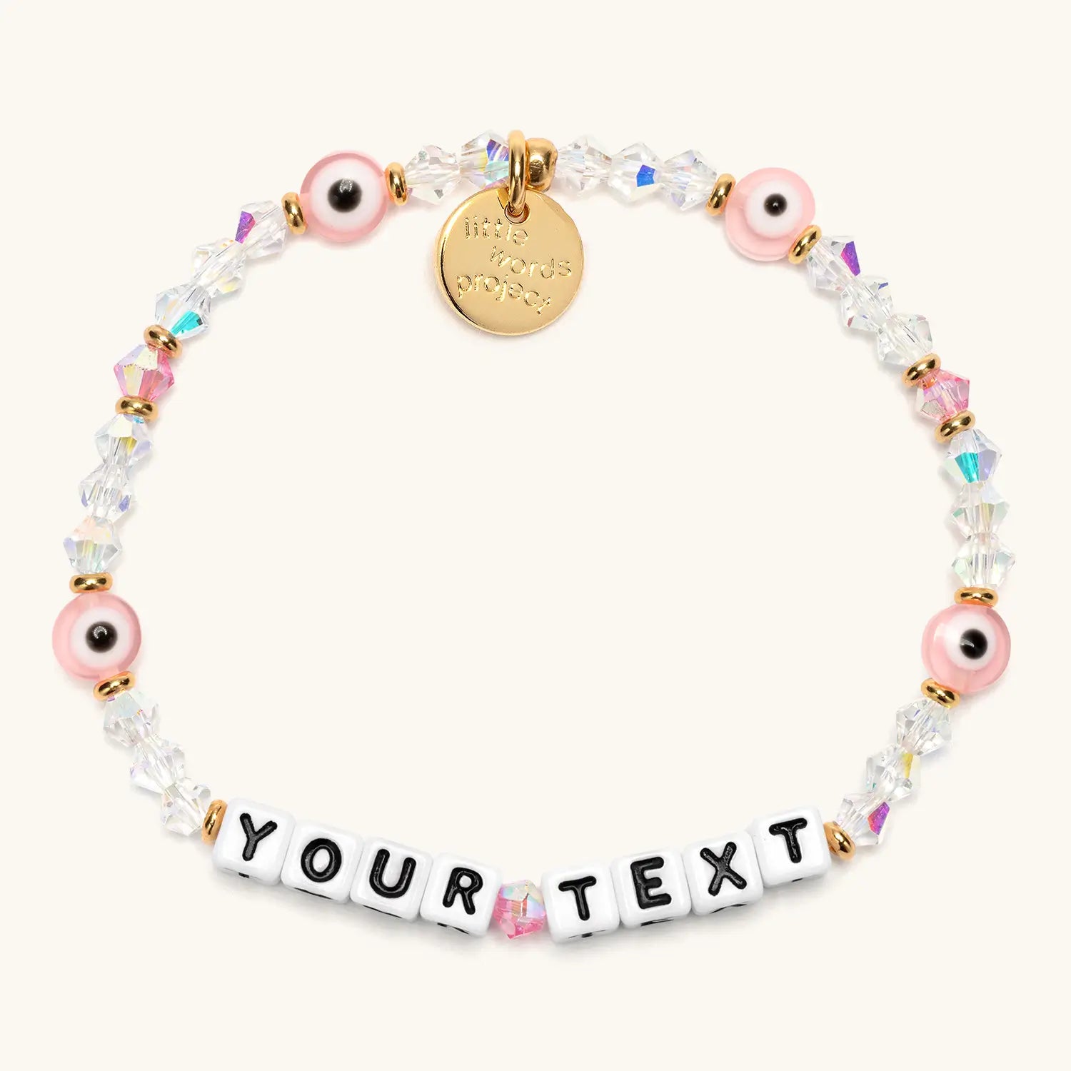 Custom Pink Evil Eye bracelet with white letter beads reading YOUR TEXT, pink evil eye beads, clear crystals, and a gold Little Words Project charm
