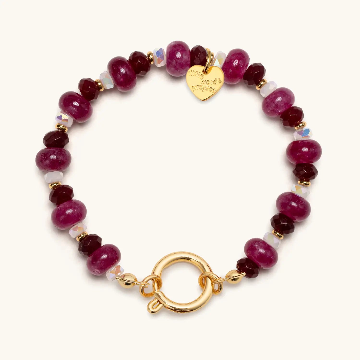Bracelet with red beads and gold clasp on a white background