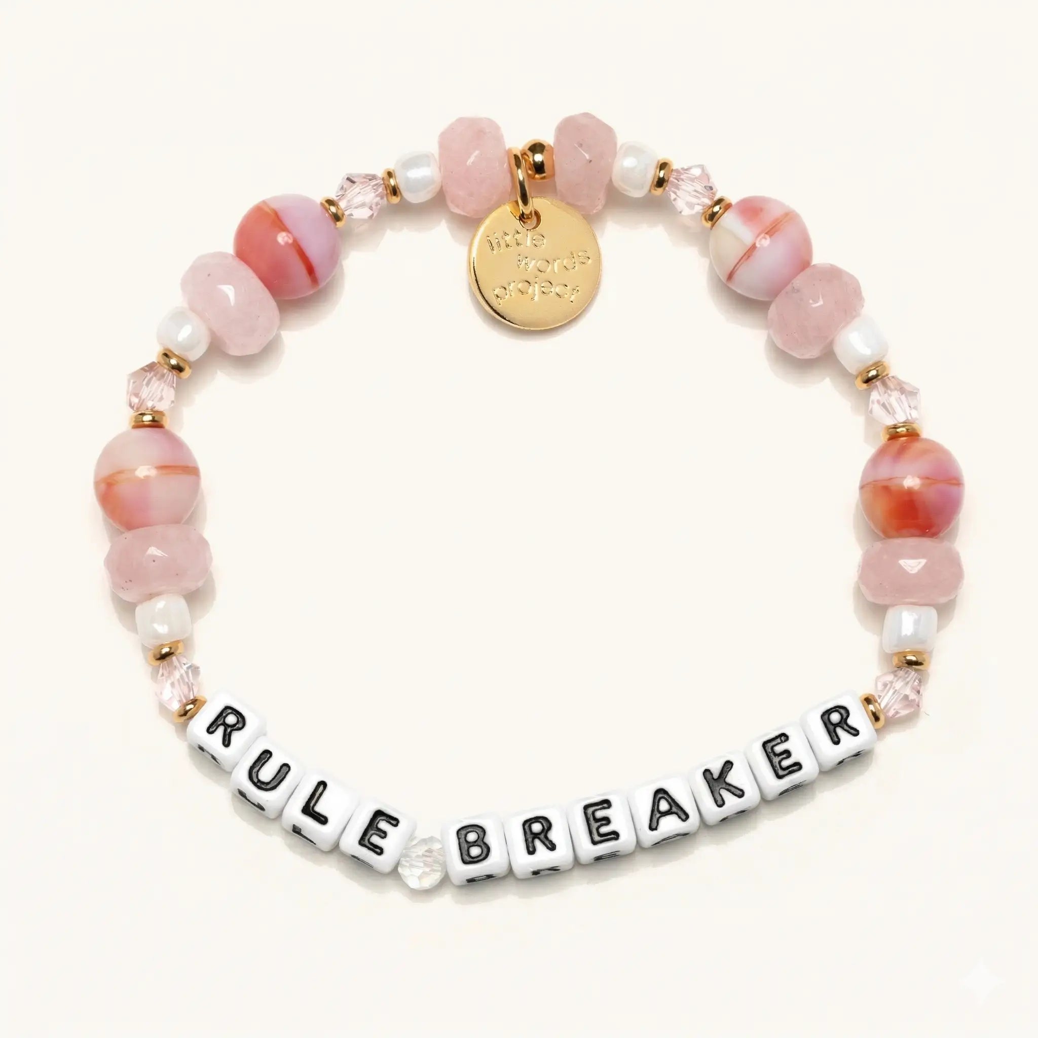 Bracelet with pink and white beads and a gold tag on a white background