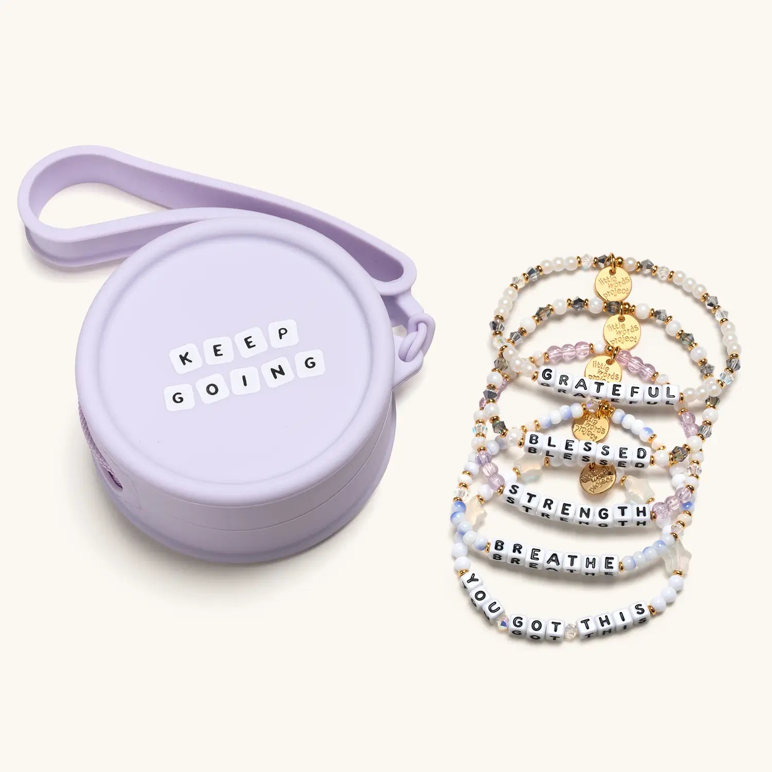 Set of beaded bracelets with motivational phrases and a purple carrying case on a white background