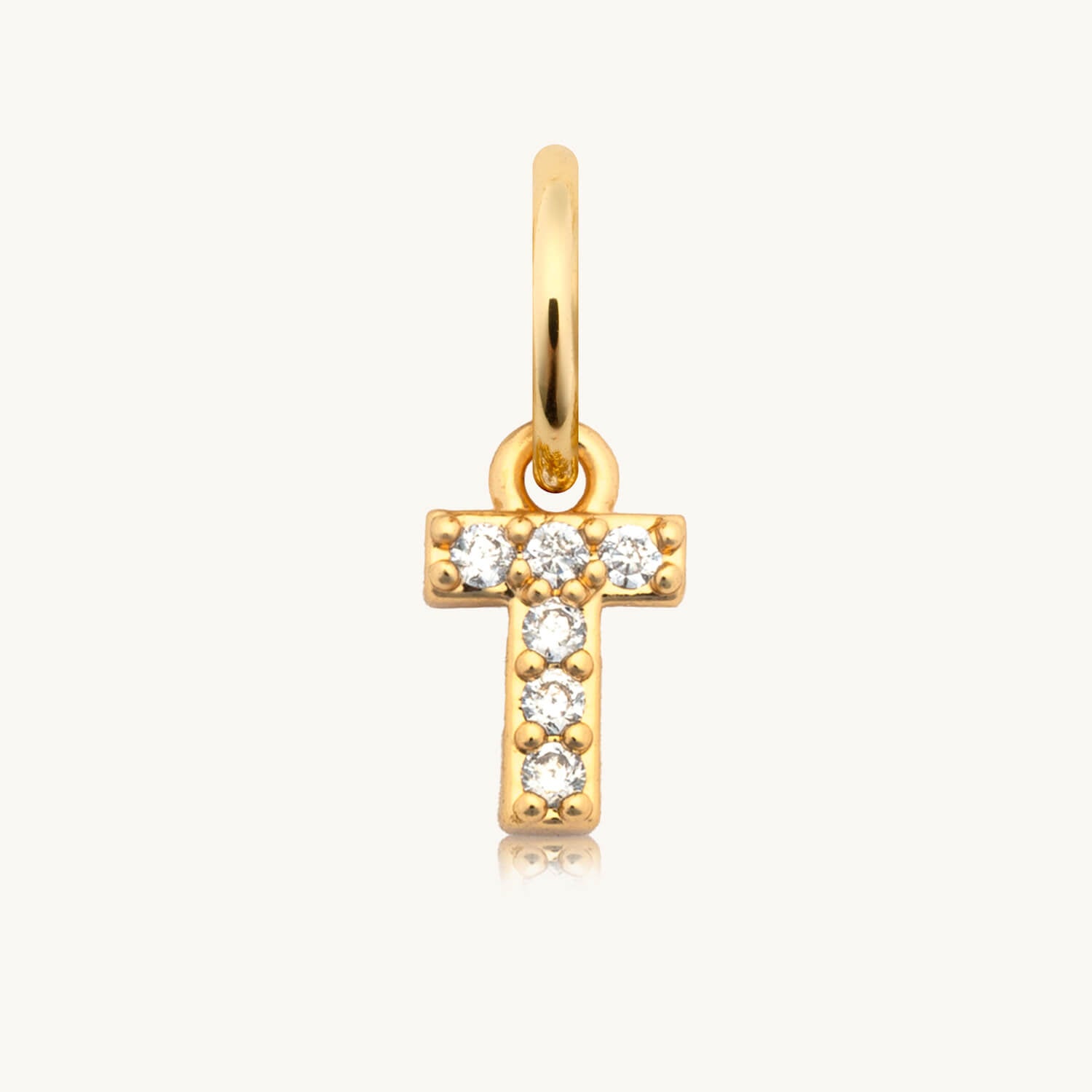 Gold cross pendant with embedded diamonds on a white background