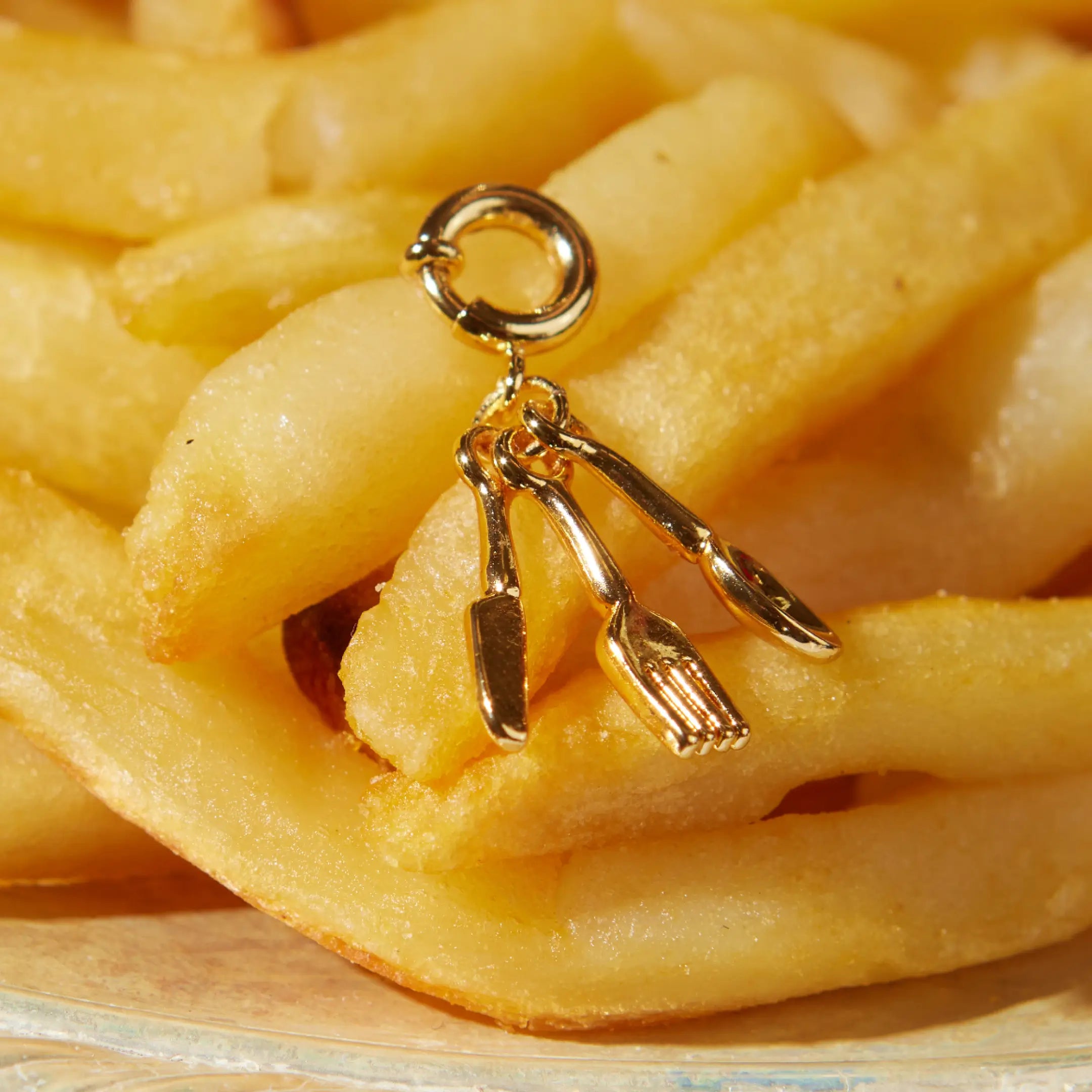 Gold charm on a pile of French fries