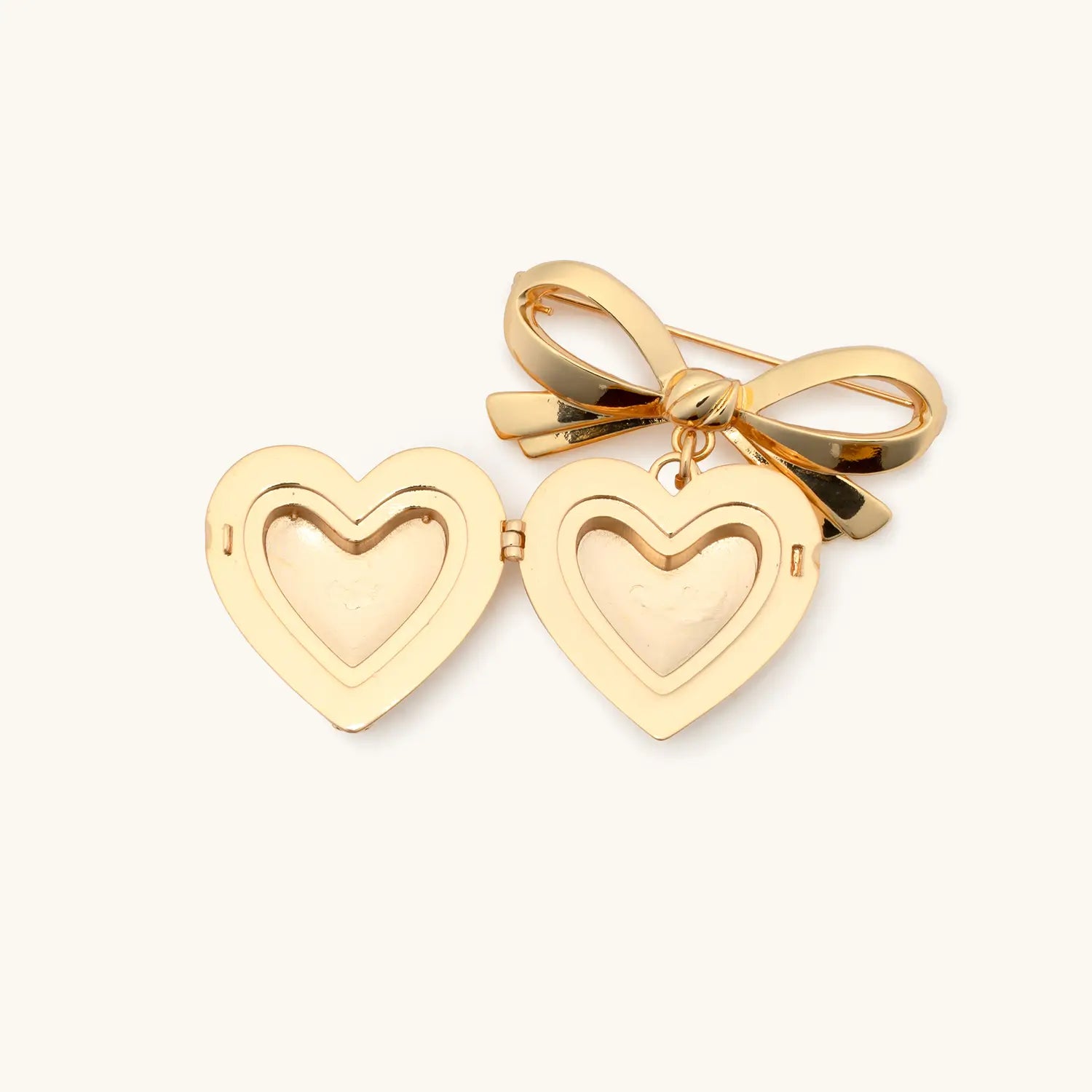 Gold heart-shaped pendant with a bow on a white background