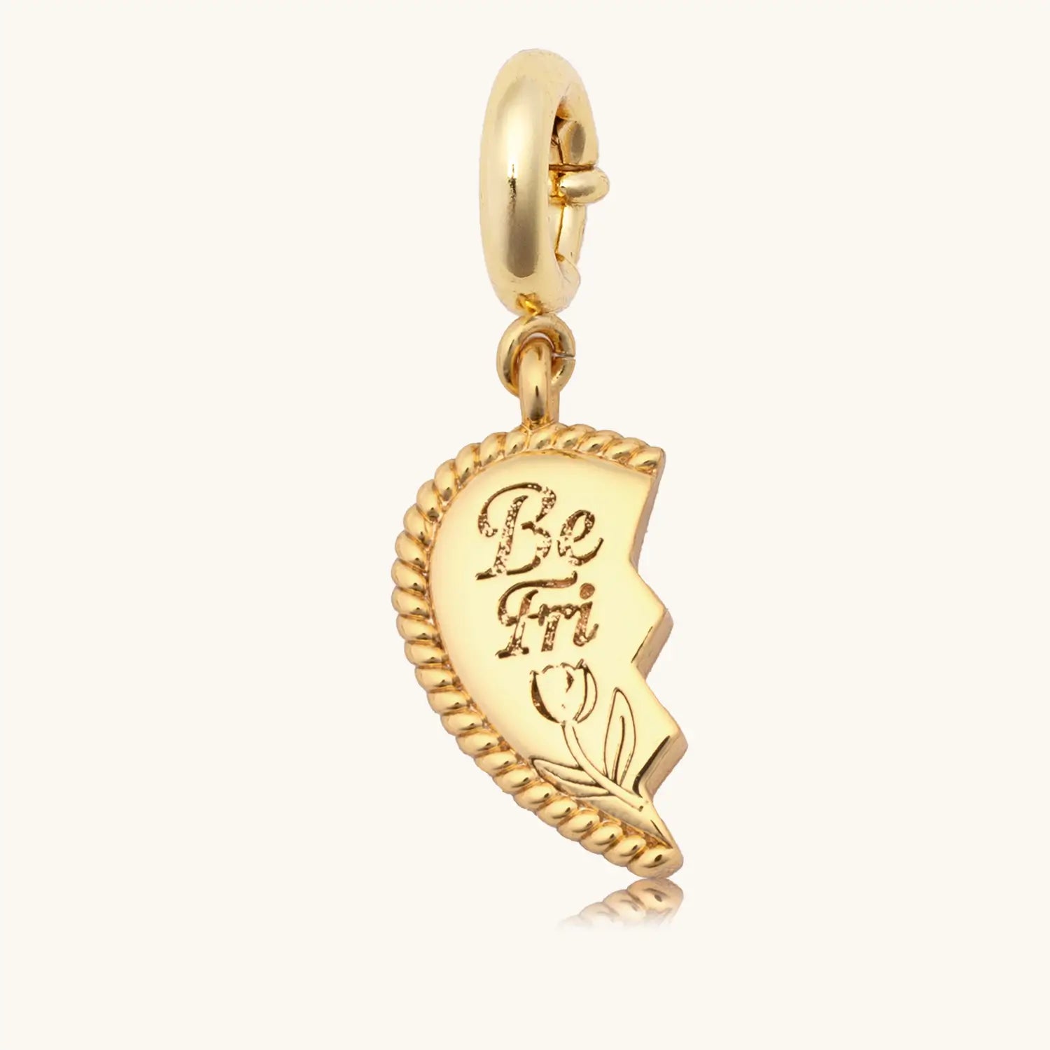 Gold charm with text on a white background