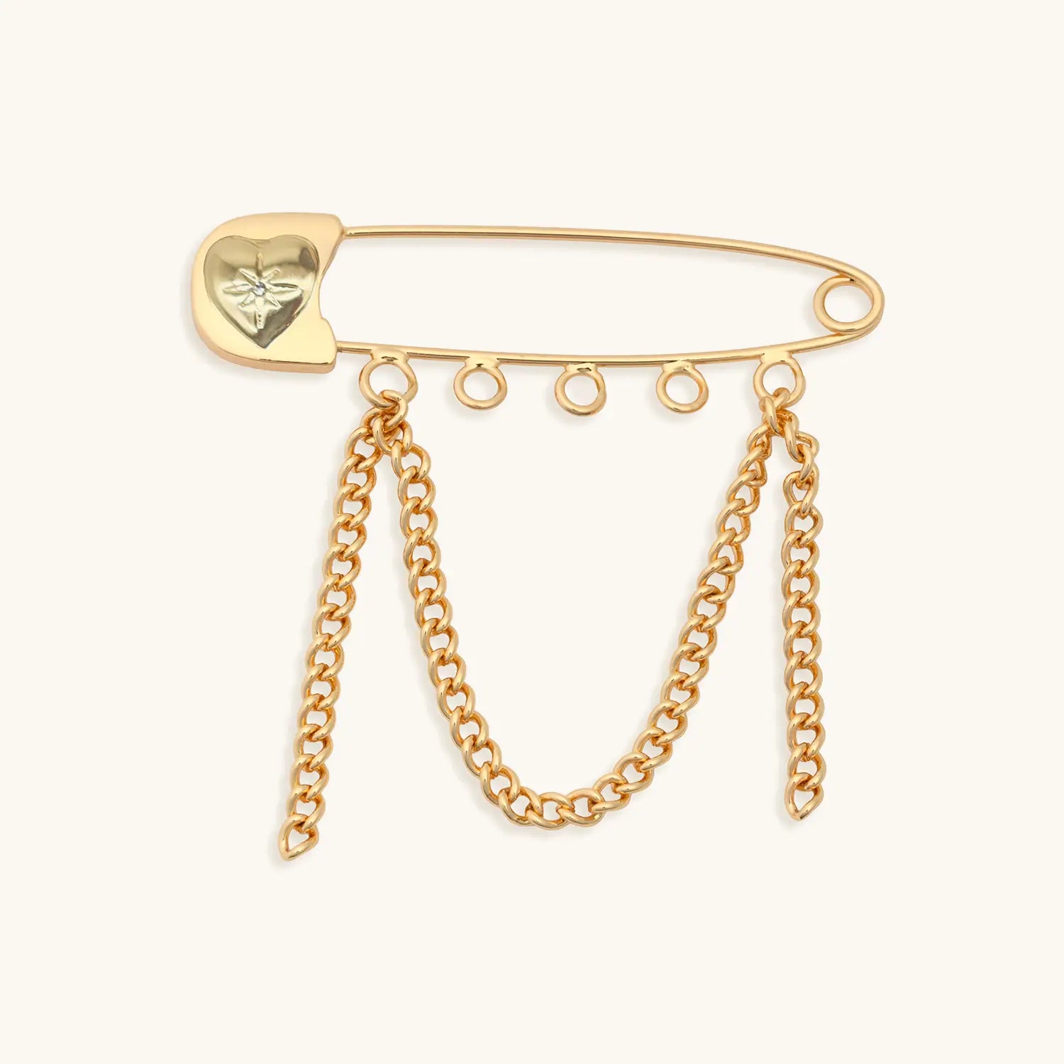 Gold safety pin with heart-shaped clasp and chain tassels on a white background
