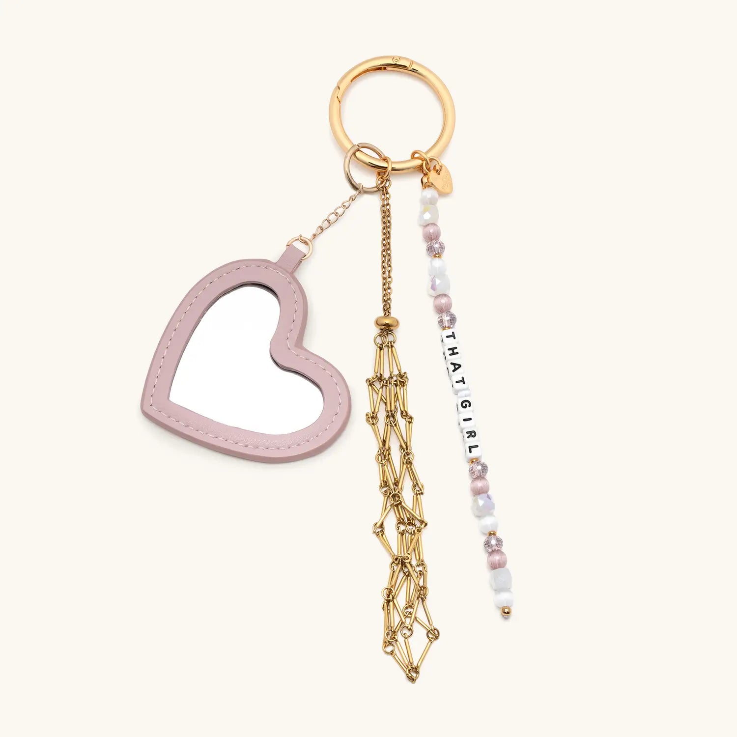 Keychain with heart-shaped charm, gold tassel, and beaded tag on a white background