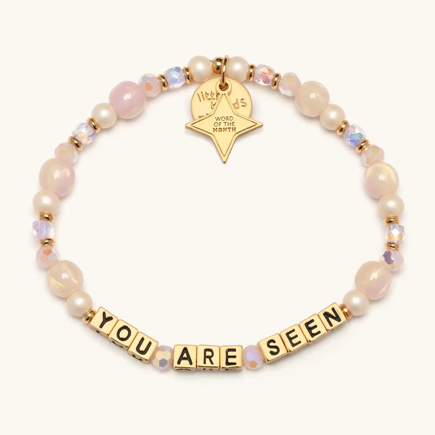 You Are Seen August Word of the Month bracelet with gold letter beads, pink and cream beads, and a gold Word of the Month star charm