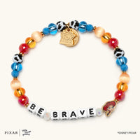 Be Brave Toy Story bracelet, blue, red and cow-print beads spelling BE BRAVE with a gold Jessie charm, flat lay