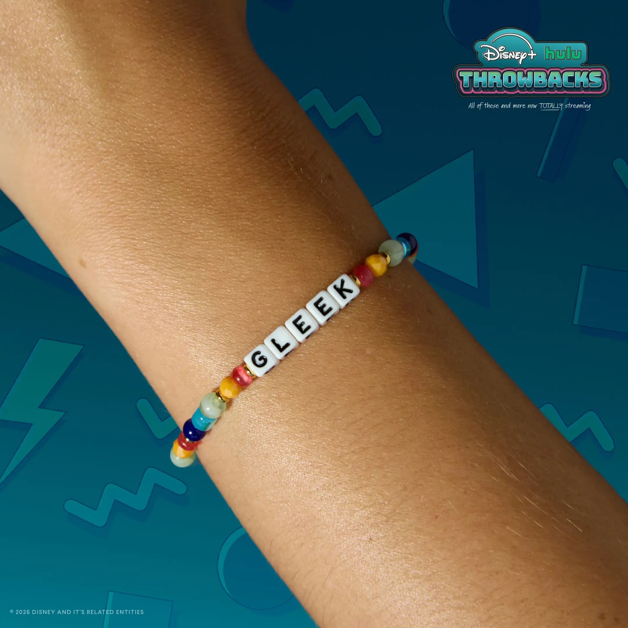 Gleek Disney+ Hulu Throwbacks bracelet worn on a wrist against a teal Y2K graphic backdrop