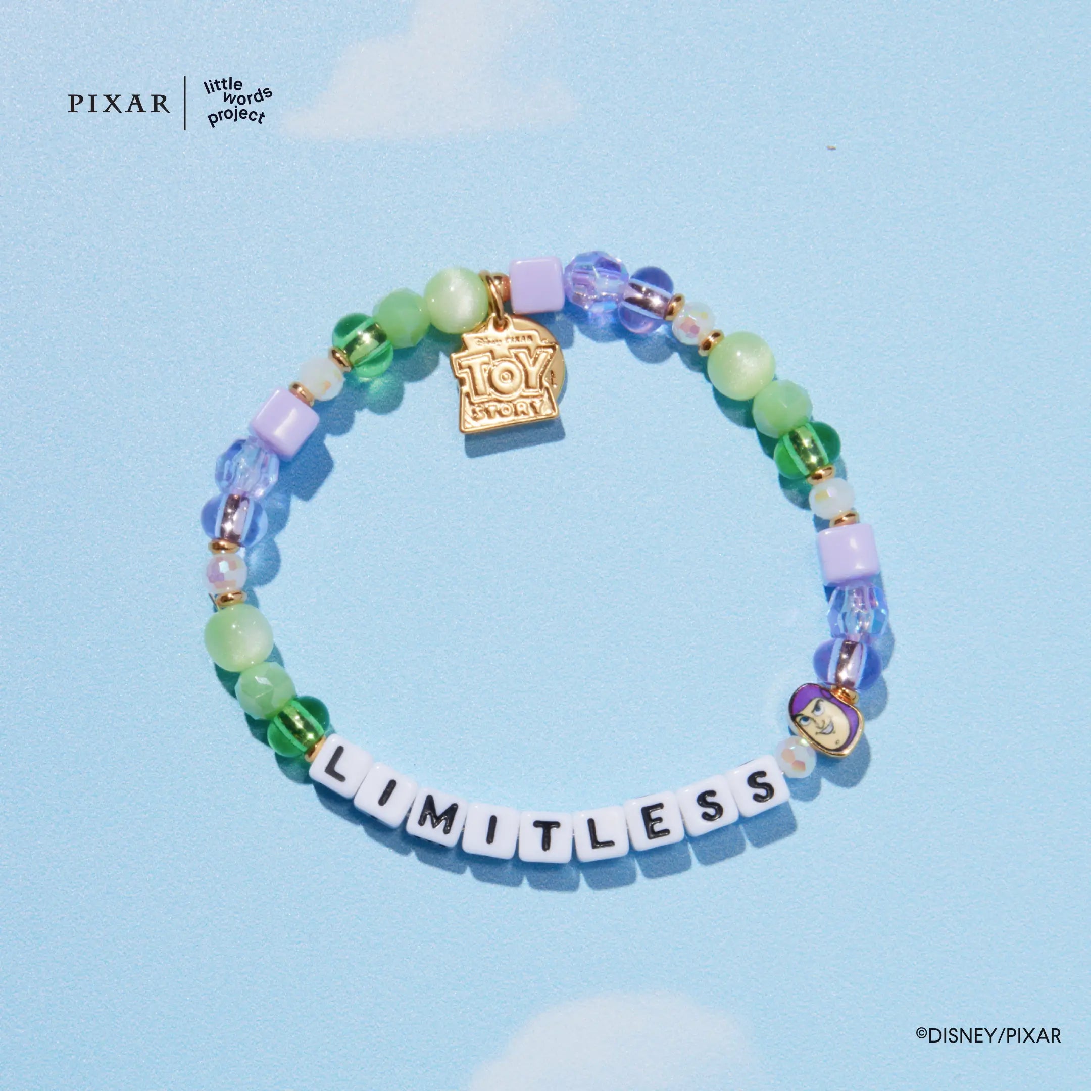 Limitless Toy Story bracelet, green and purple beads with a gold charm, on a blue background