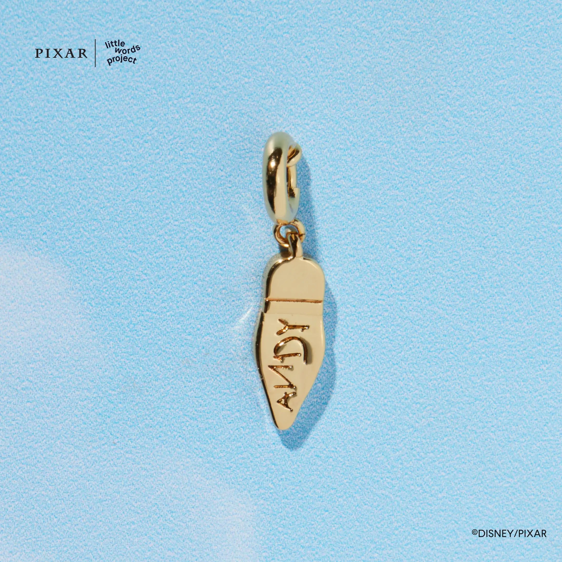 Gold Woody boot charm engraved ANDY from the Reach for the Sky Toy Story set, detail on blue