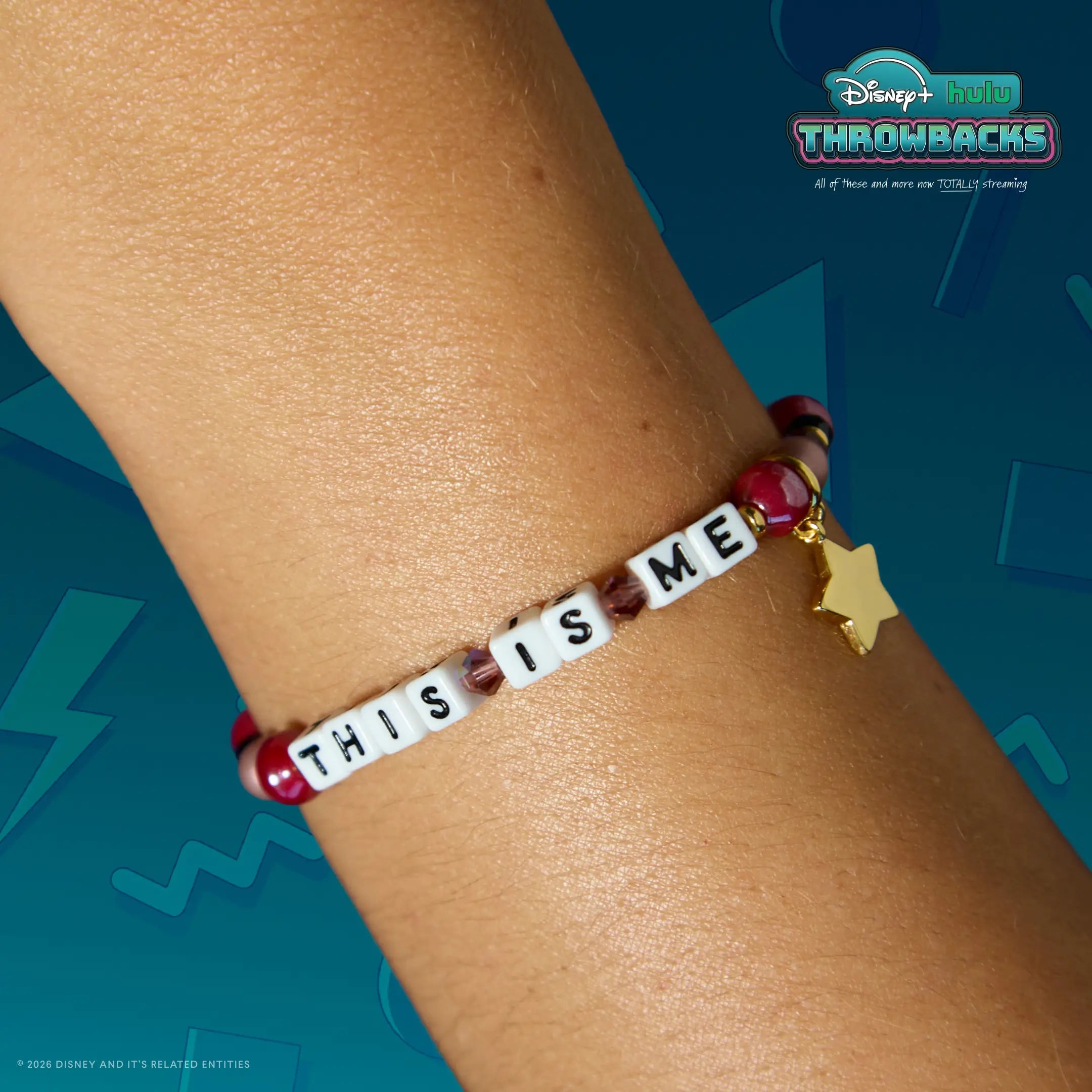 This Is Me Disney+ Hulu Throwbacks bracelet worn on a wrist against a teal Y2K graphic backdrop