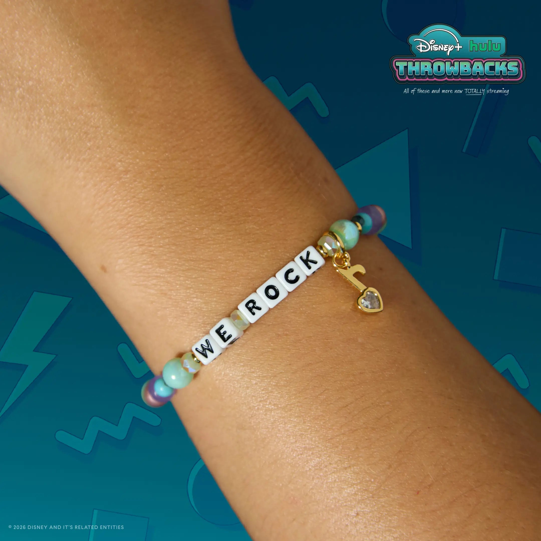 We Rock Disney+ Hulu Throwbacks bracelet worn on a wrist against a teal Y2K graphic backdrop