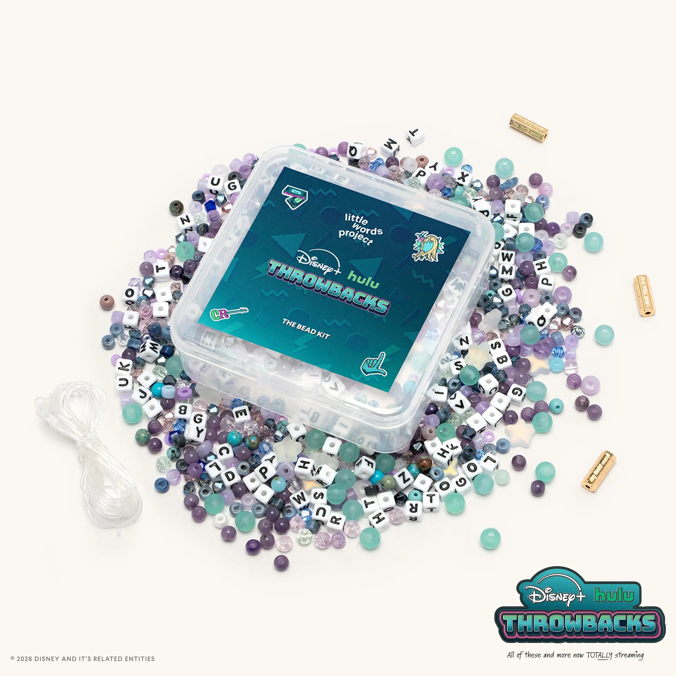 Y2K Bead Kit from Disney+ Hulu Throwbacks, clear case surrounded by teal, purple, gray, and clear beads with white and black letter blocks, gold closure beads, and elastic cord