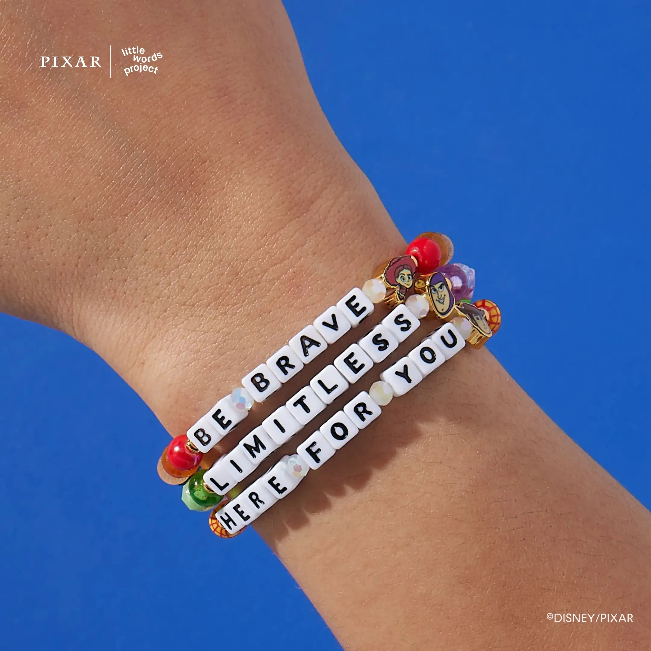 You've Got a Friend set, Be Brave, Limitless and Here For You Toy Story bracelets stacked on a wrist