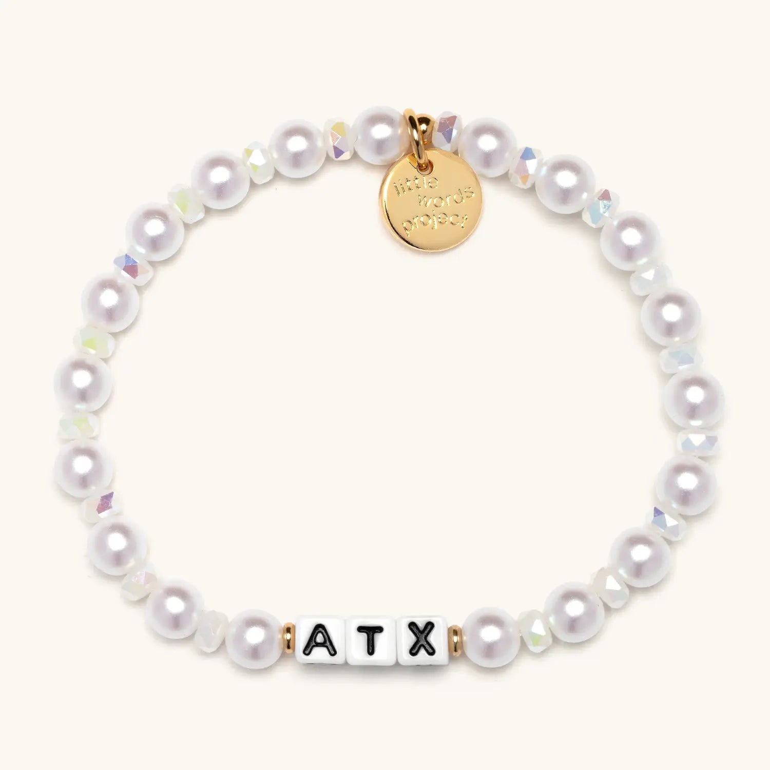 Pearl bracelet with a gold tag and 'ATX' beads on a white background