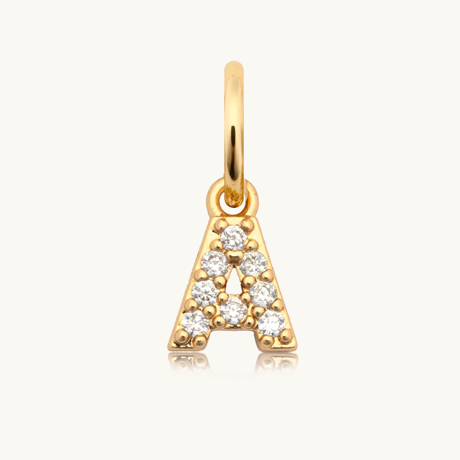 Gold pendant with letter 'A' design on a white background
