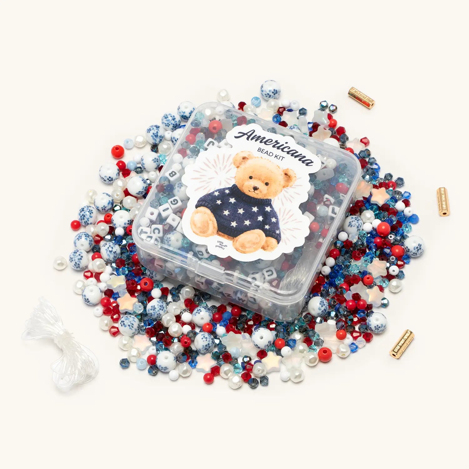 Americana Bead Kit flat-lay of red, white, and blue beads, crystals, and letter blocks spread out on a white background