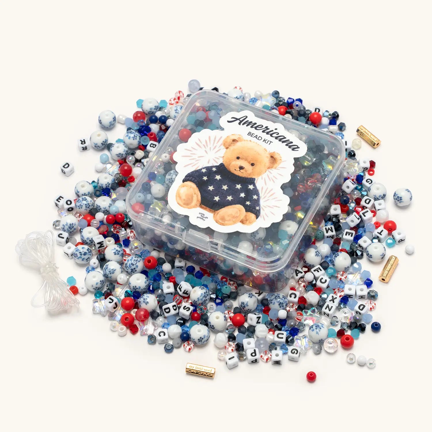 Americana Bead Kit contents flat-lay showing red, white, and blue letter beads, star-shaped beads, and patriotic crystal beads