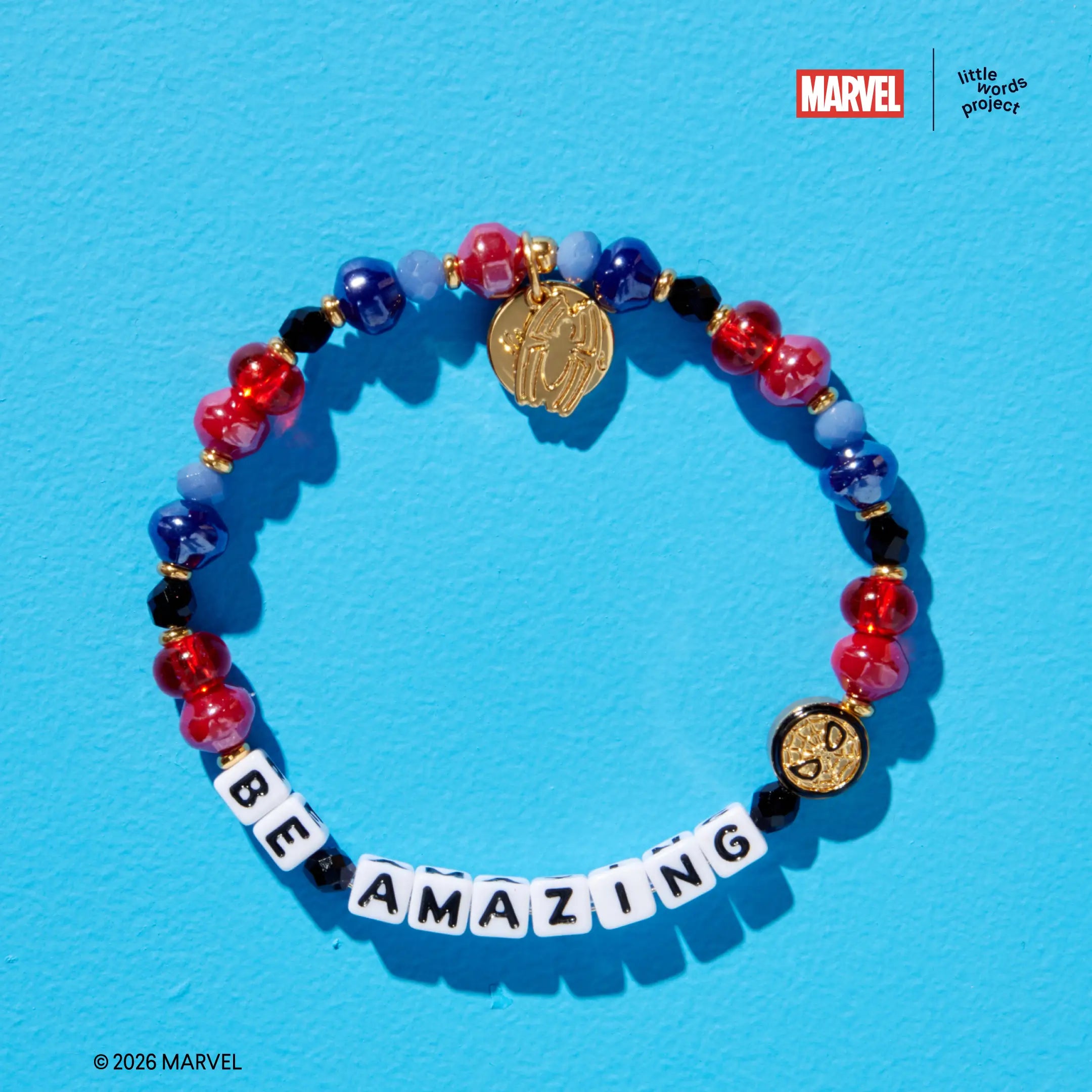 Be Amazing bracelet from Marvel's Spider-Man collection, flat-lay on blue background, red, navy blue, and black glass beads with gold Spider-Man enamel casted bead