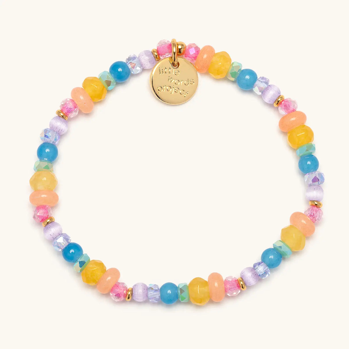 Jewel Party Bracelet Base- Britt Horton in the Mini Jewel Party bead pattern, blue, yellow, peach, lavender, and pink semi precious stone, crystal, glass, and cat eye beads with gold accents, flat-lay on cream background