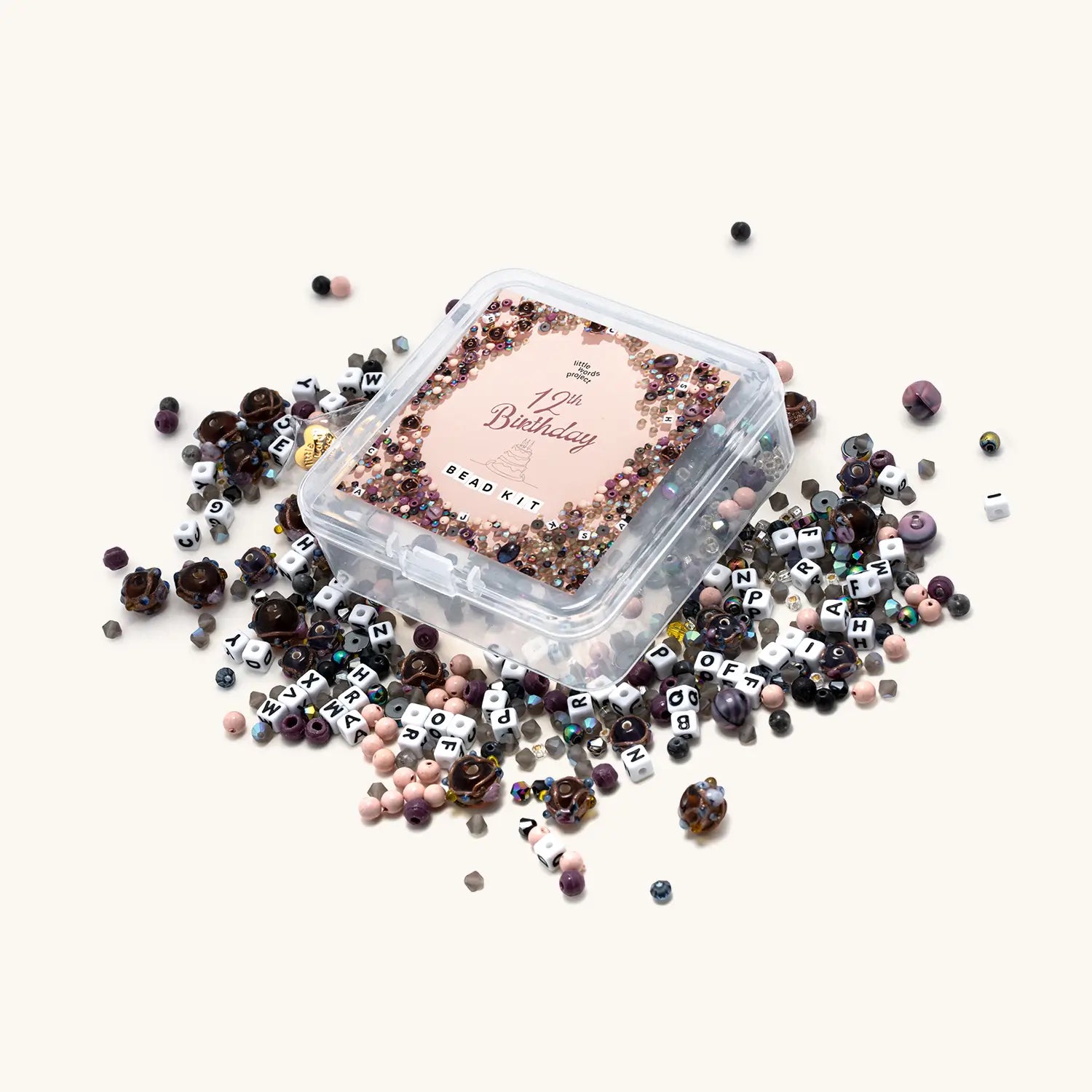 Decorative letter beads in a clear container on a white background