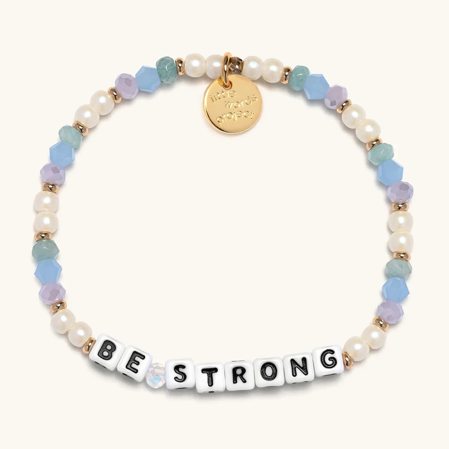 Multicolored beaded bracelet with a gold tag and letter tiles spelling 'BE STRONG' on a white background