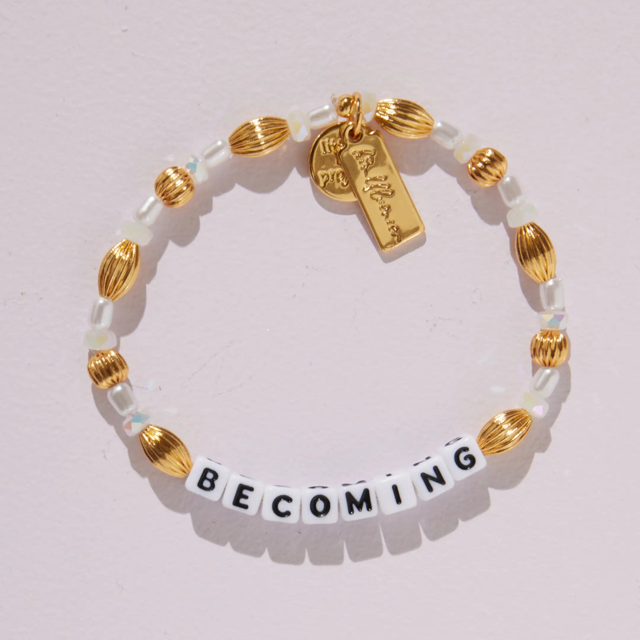 Becoming- Nika Diwa on-model wrist shot, Becoming word bracelet with gold plated brass oval beads and opalescent stone beads