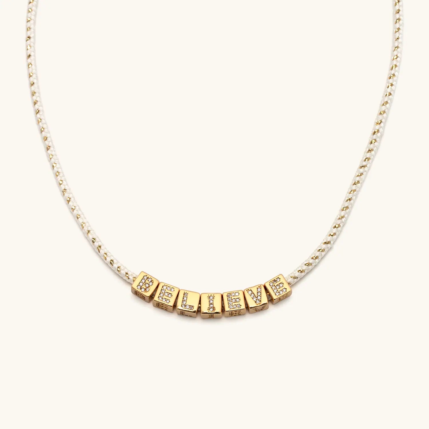 Gold necklace with letters on a white background