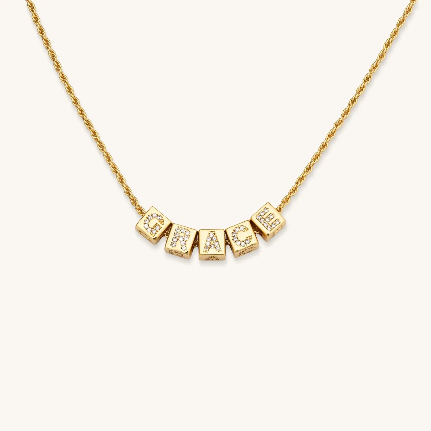Gold necklace with letters on a white background