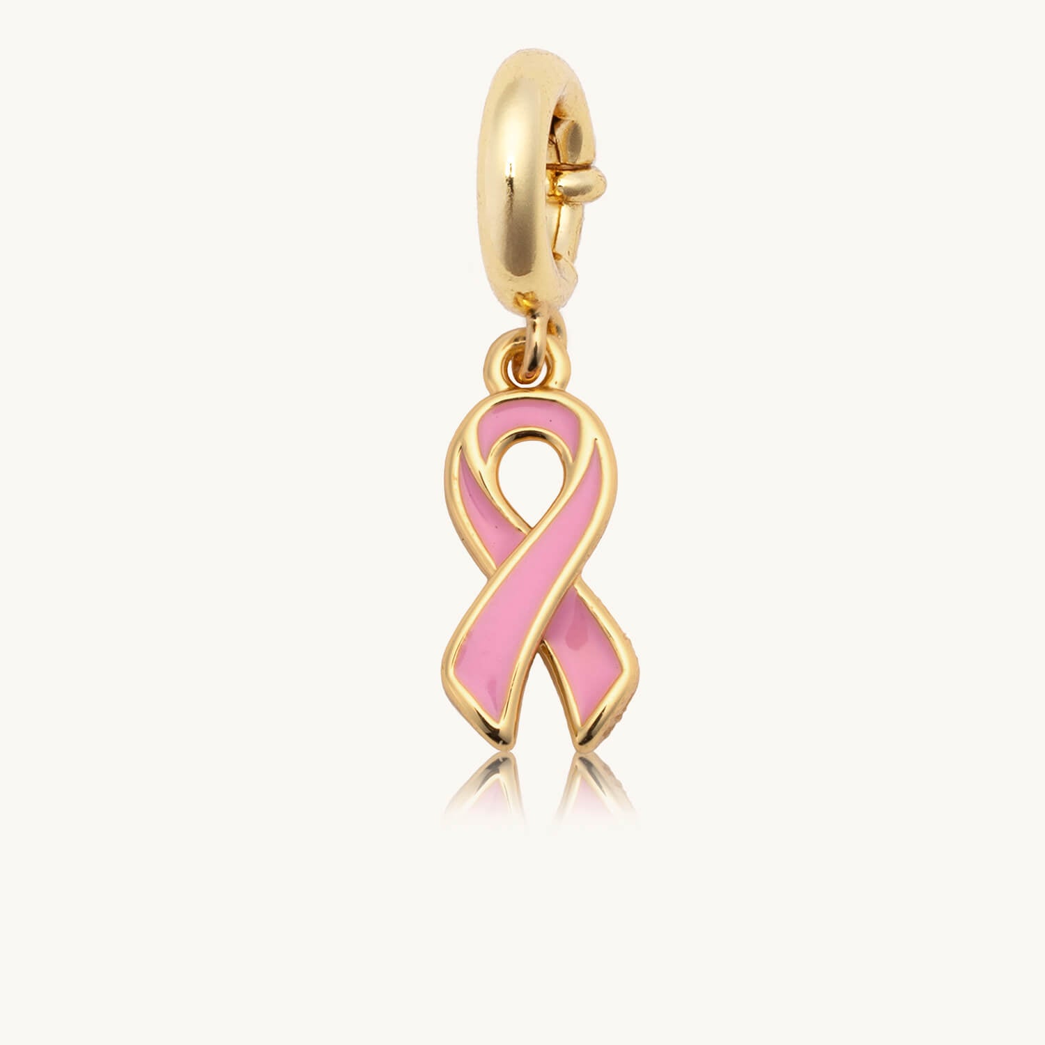 Gold charm with a pink ribbon on a white background