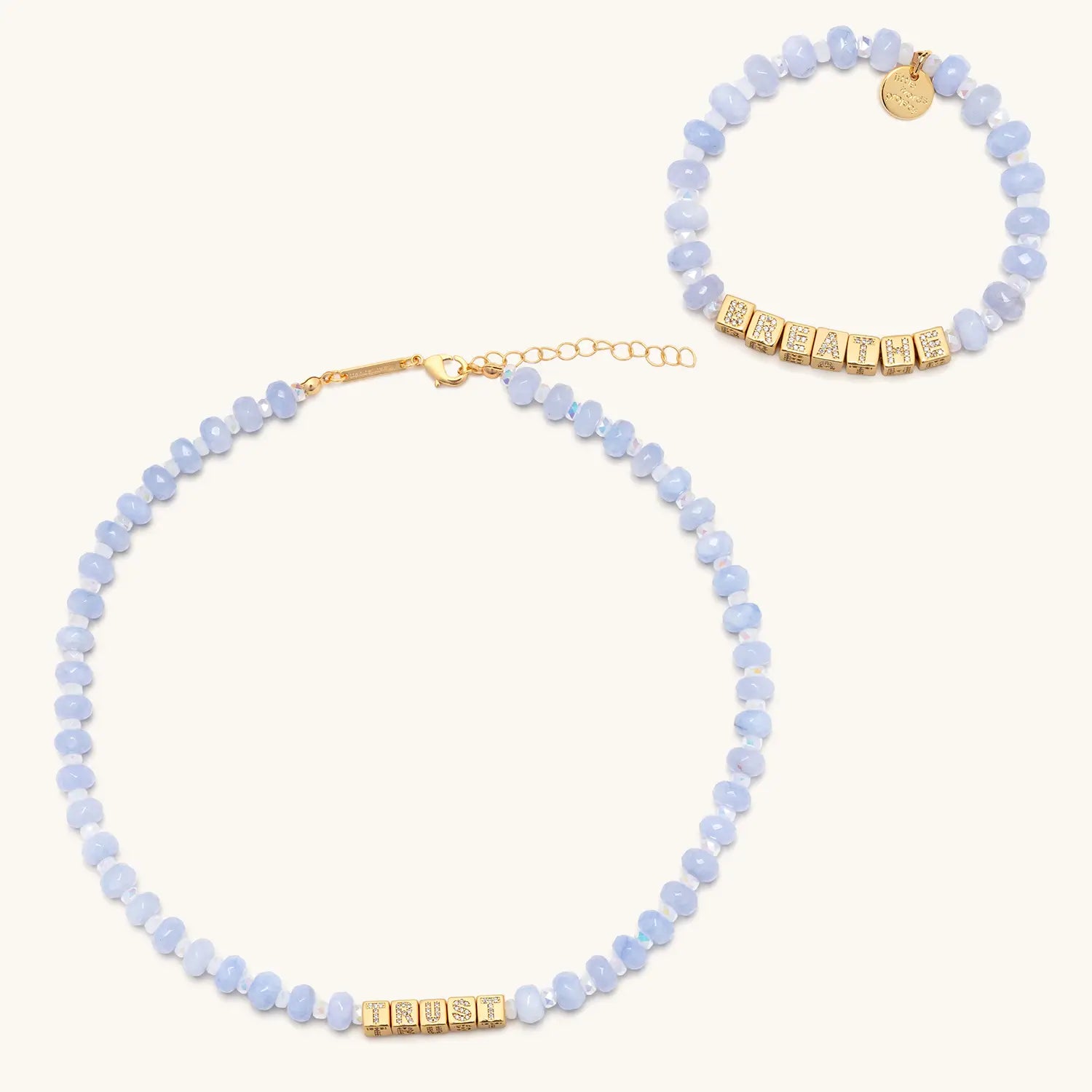 Necklace and bracelet set with blue beads and gold accents on a white background