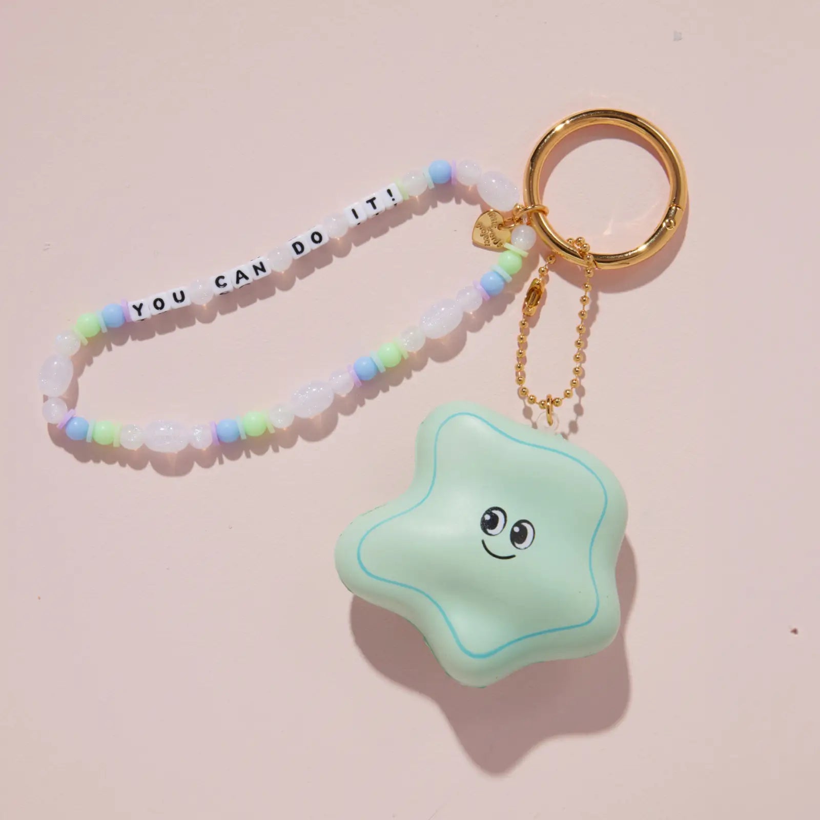 Star-shaped bag charm with a smiley face on a pink background