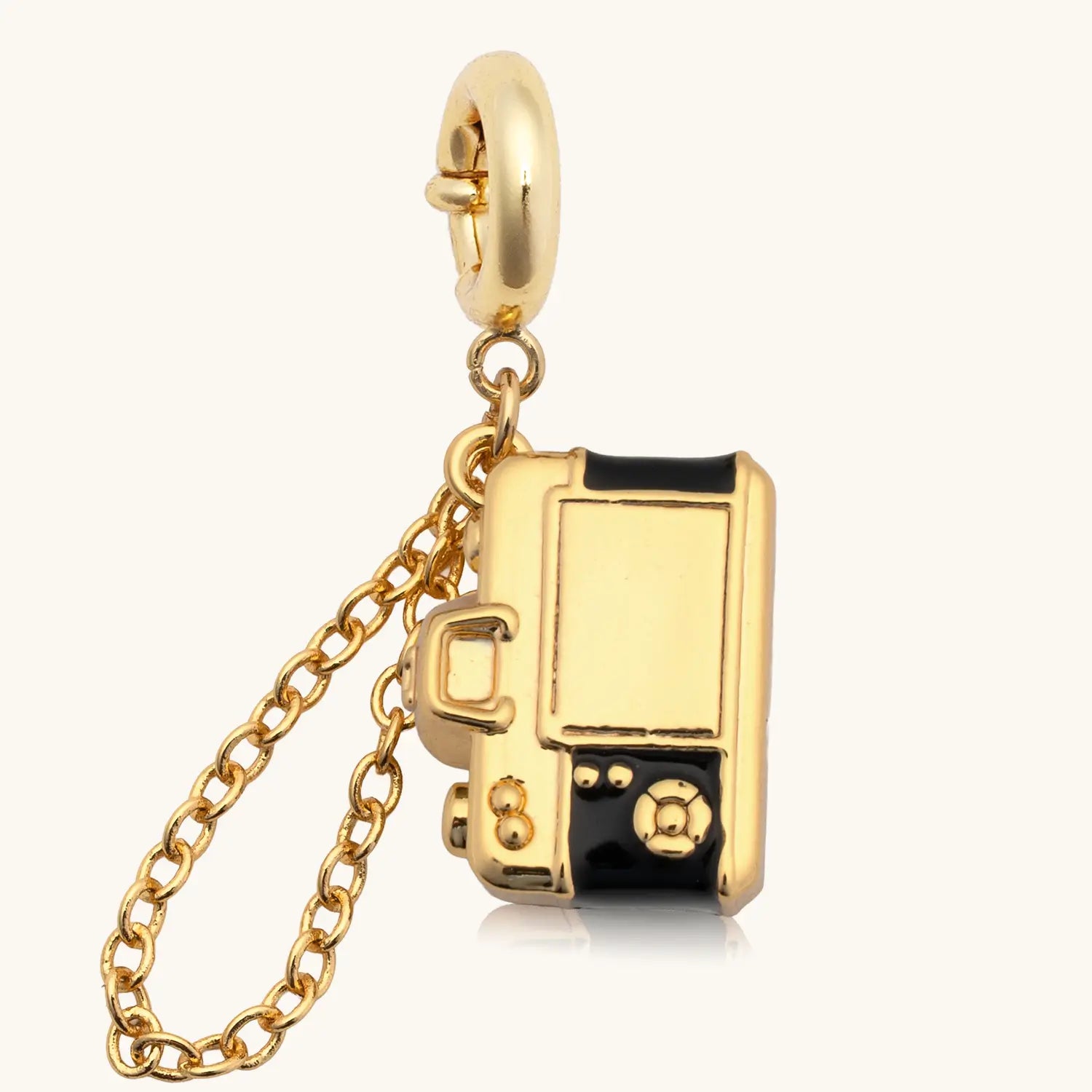 Gold and black camera charm with a chain on a white background