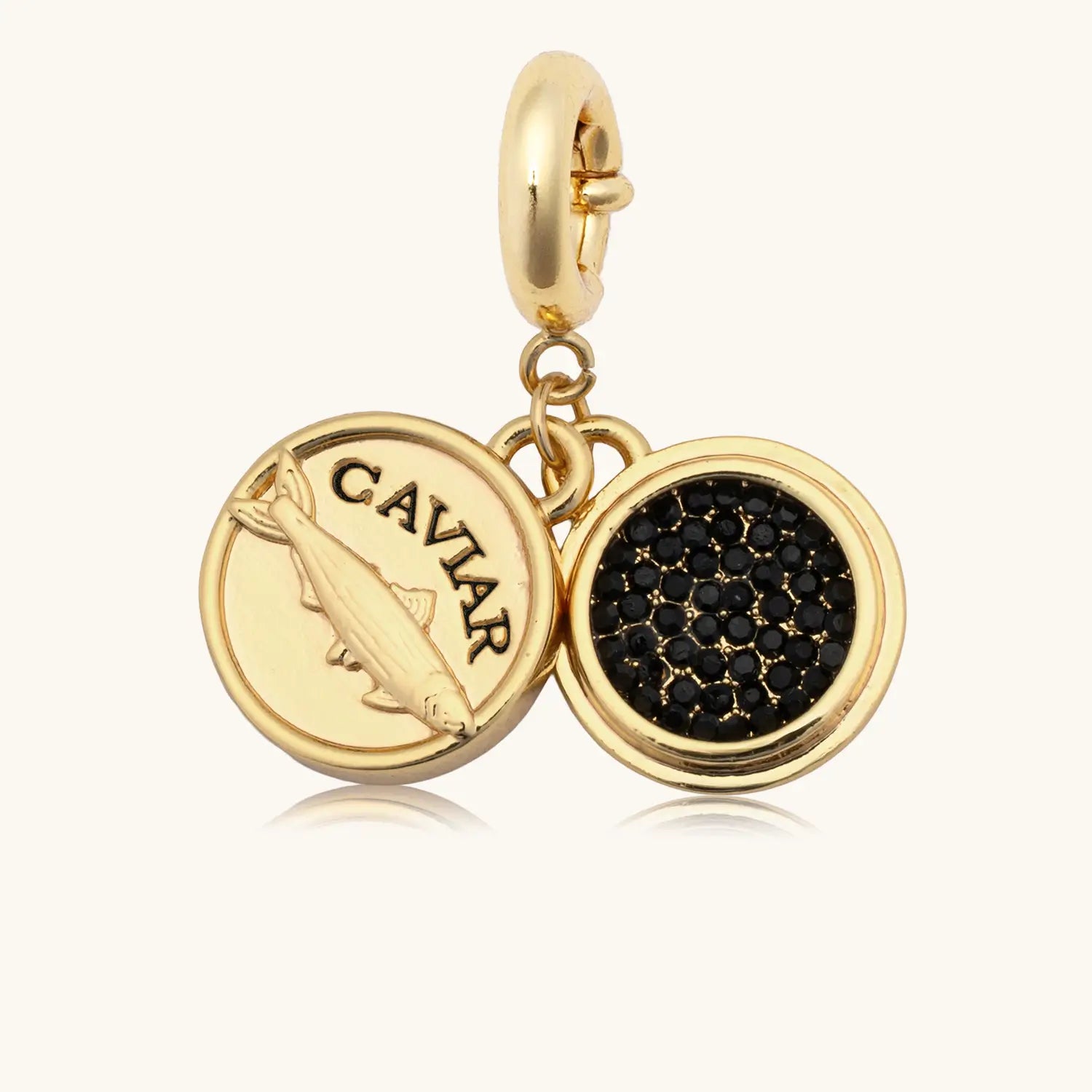 Gold charm with 'CAVIAR' text and black caviar design on a white background