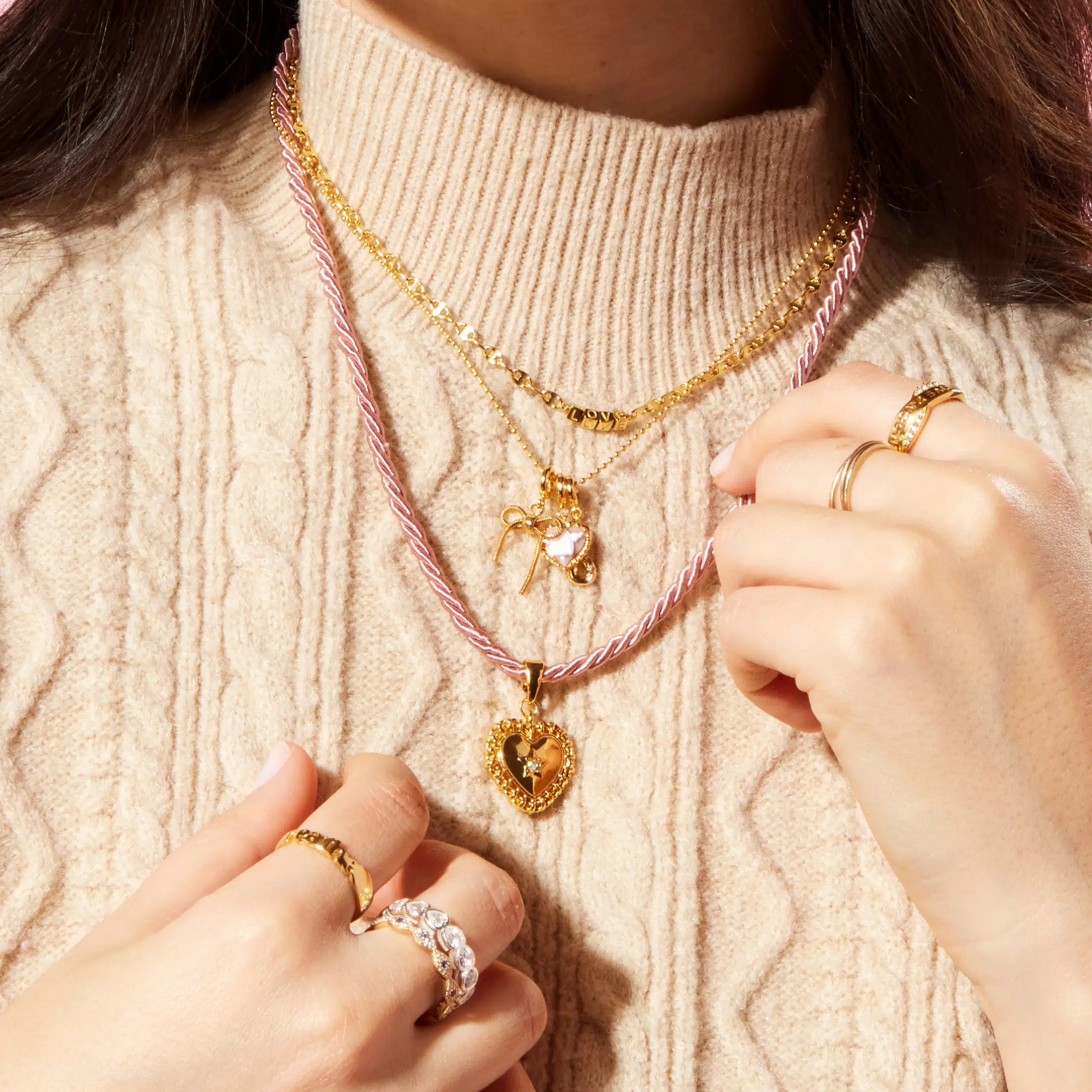 Person wearing multiple gold necklaces and rings