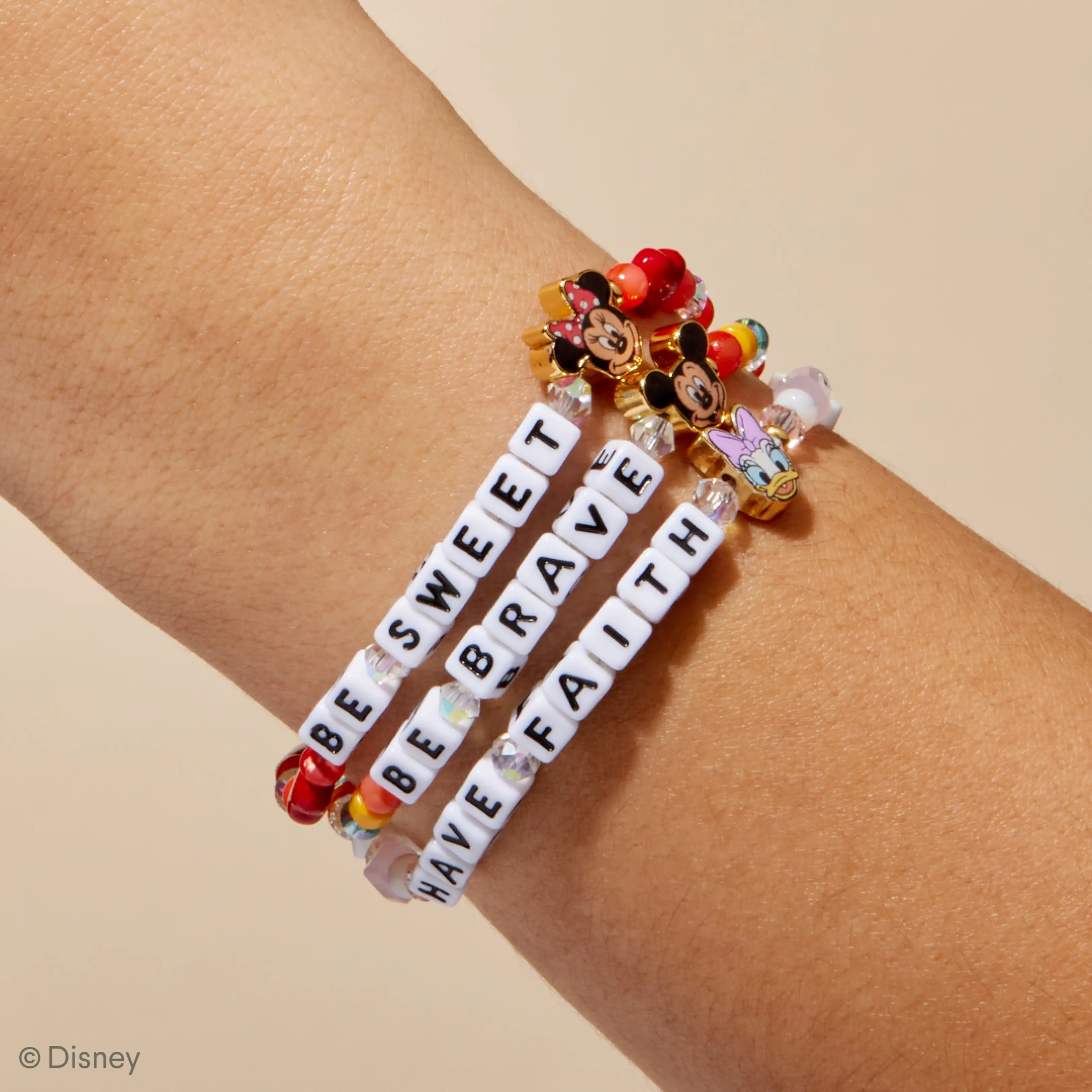 Bracelet with motivational phrases on a wrist against a beige background