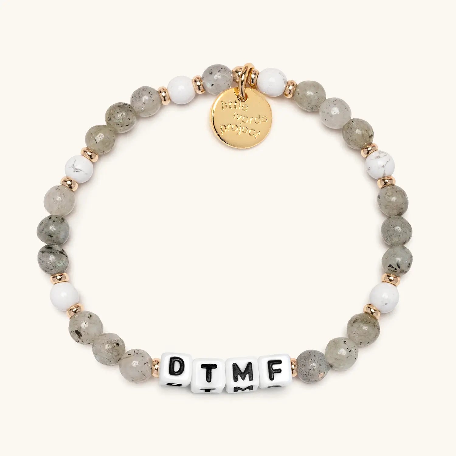 Beaded bracelet with gold tag and 'DTMF' on a white background