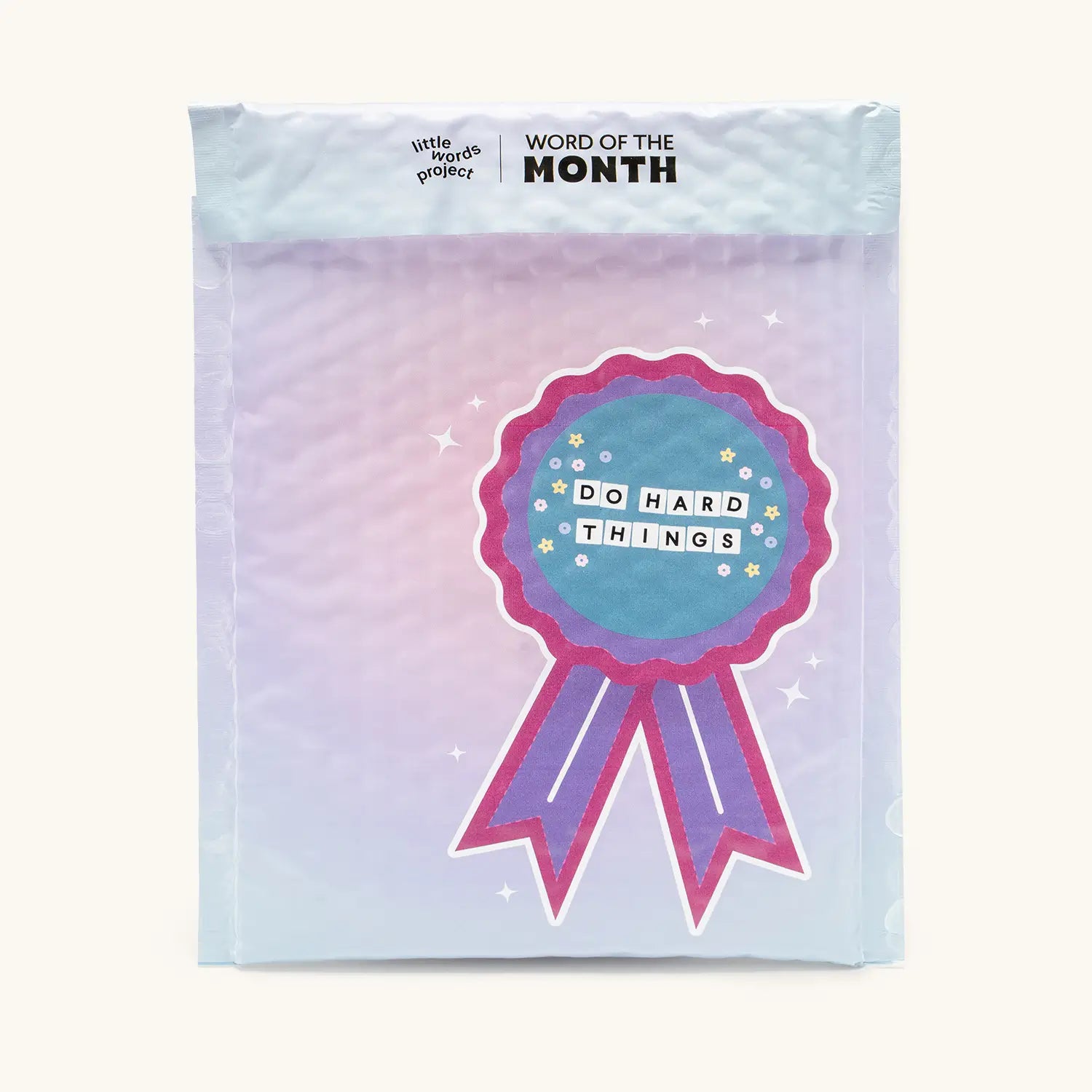 Word of the Month subscription mailer for Do Hard Things September, printed with a pink and purple award ribbon illustration on a pastel gradient