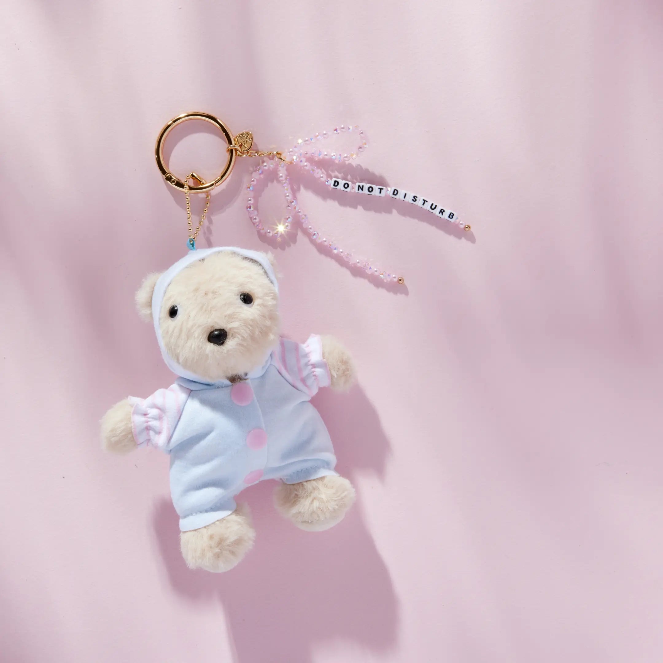 Do Not Disturb plush bear bag charm with beaded bow, detail shot on pink