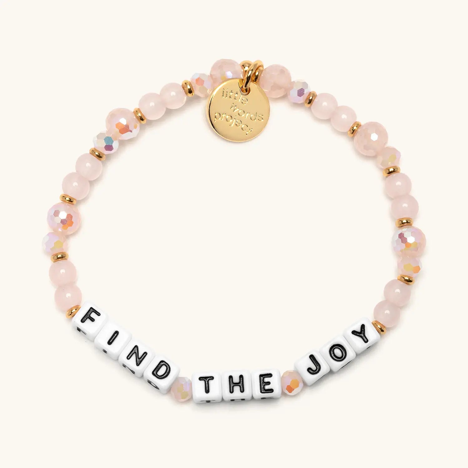 Find The Joy bracelet with soft pink and white beads and white letter beads, flat lay