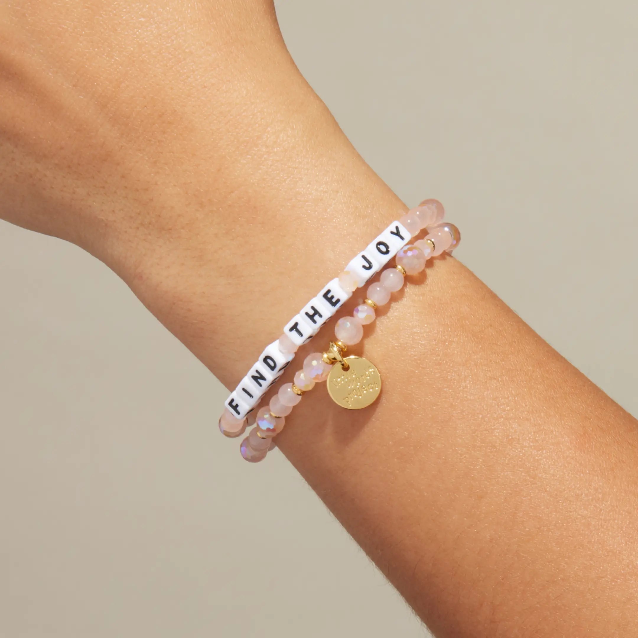 Find The Joy pink beaded bracelet stacked on wrist, on-model