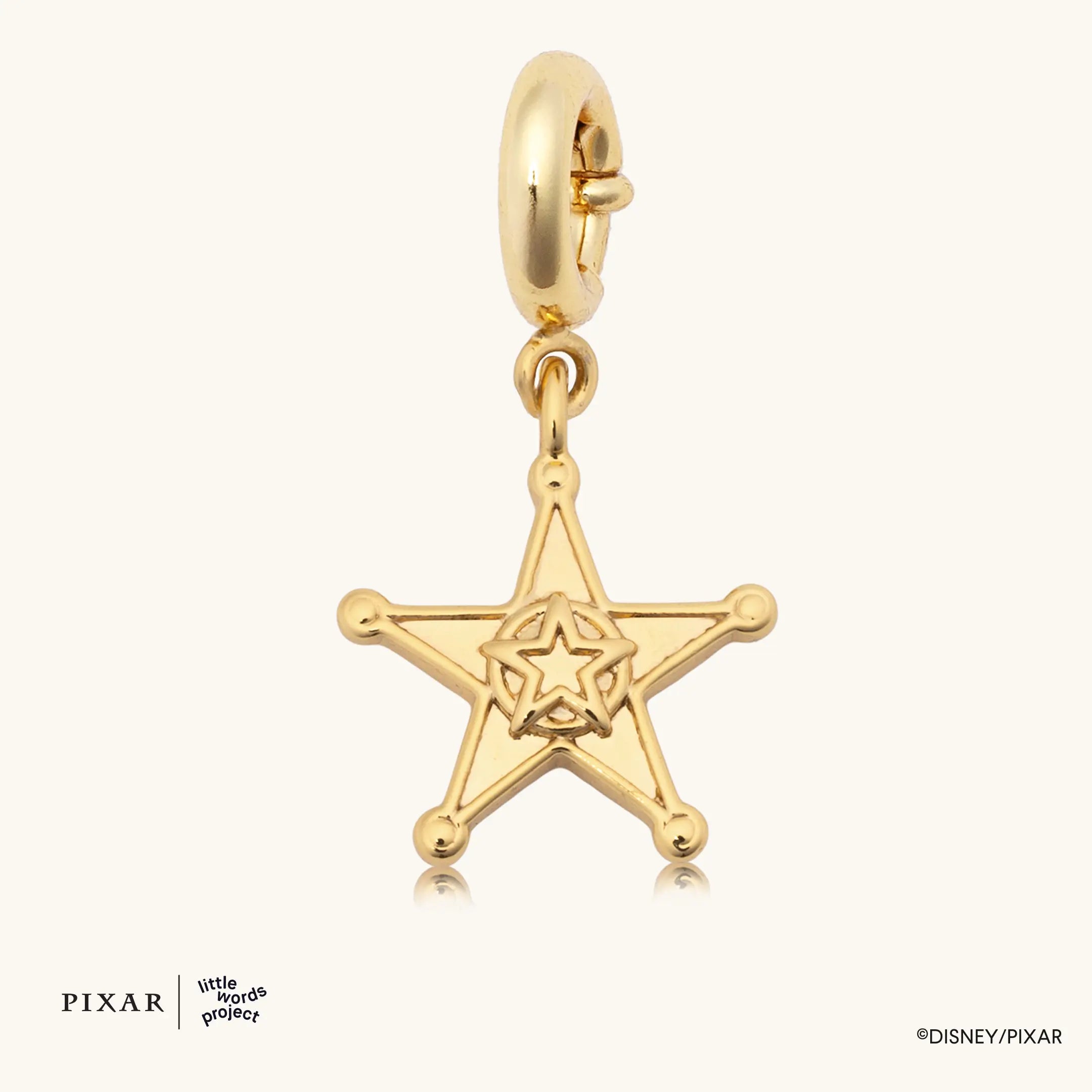 Woody's Sheriff Badge, gold Toy Story sheriff star charm, flat lay